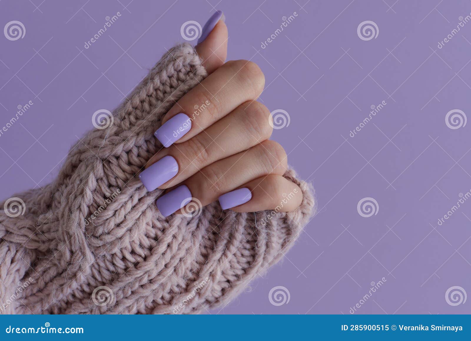 female's hand with delicate nails of trendy lavender color