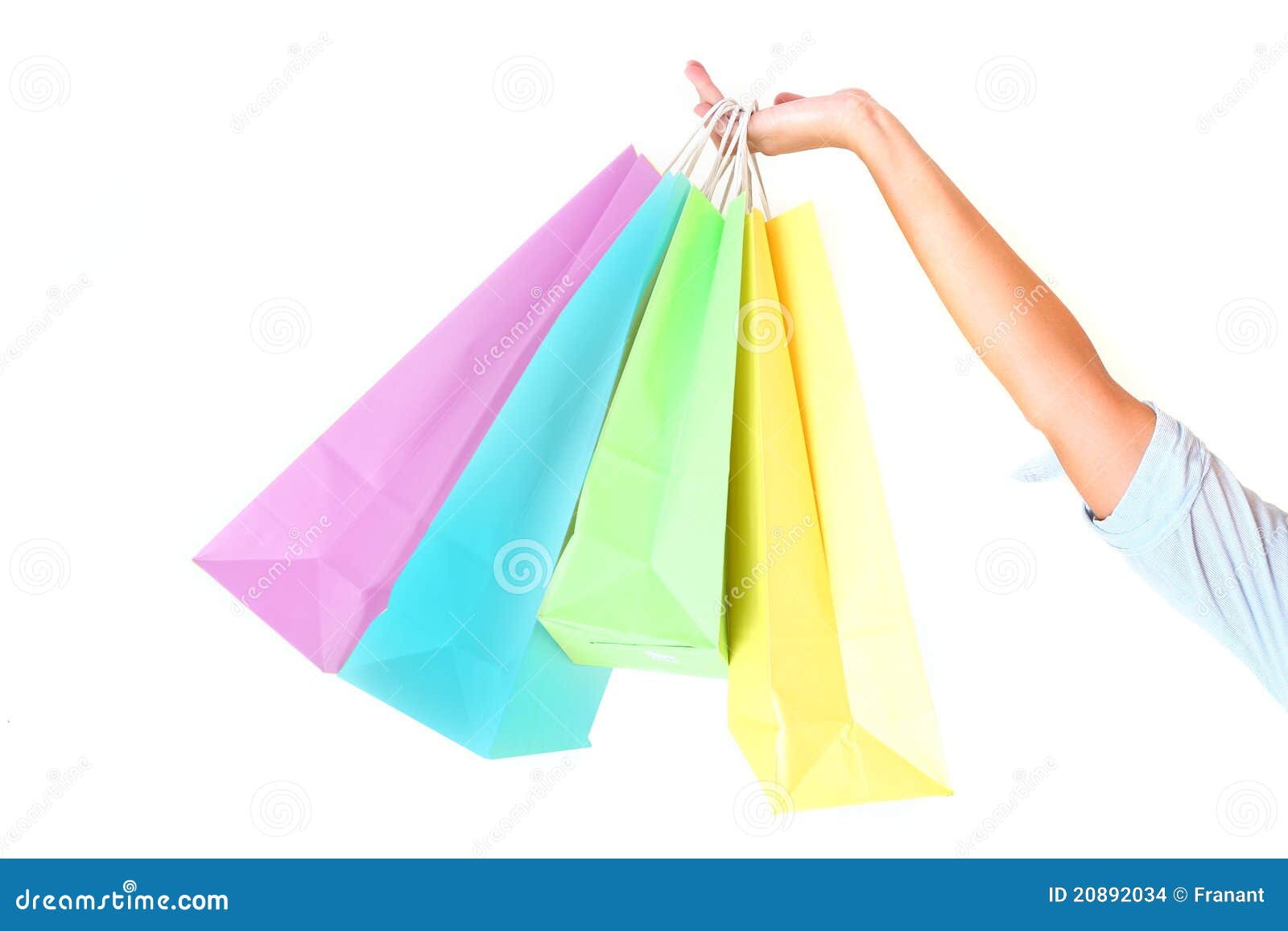 female's hand holding colorful shopping bags
