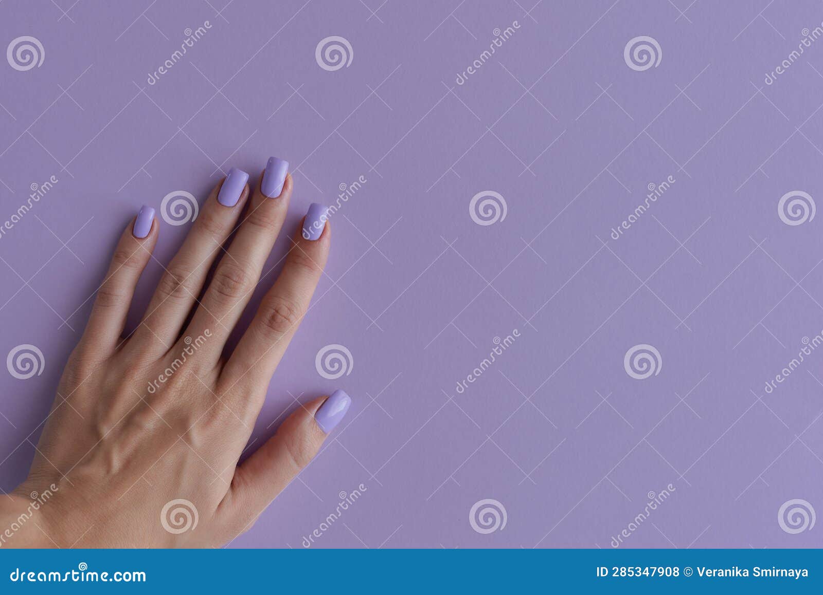 female's hand with nails of purple color
