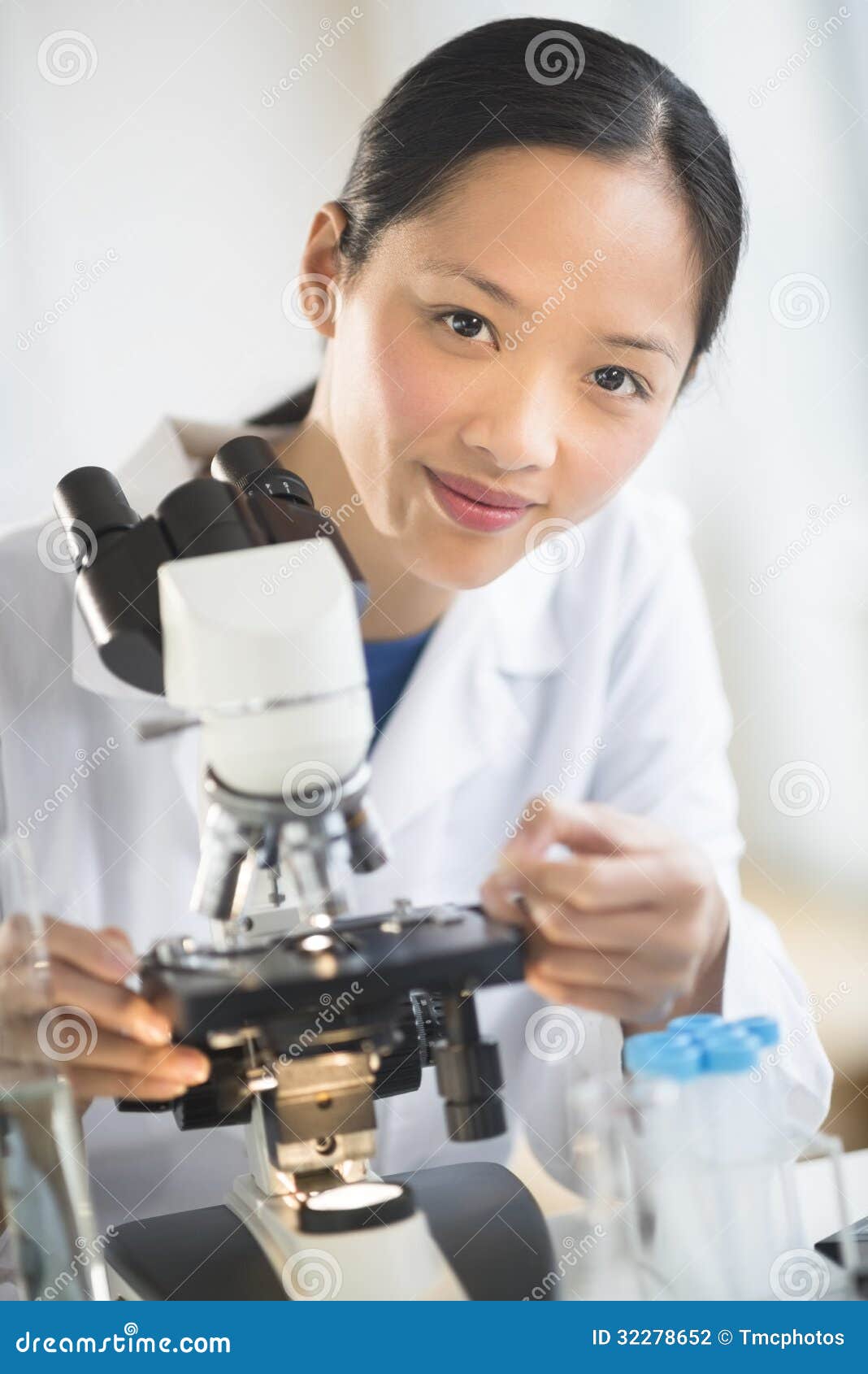 Female Scientist Smiling While Using Microscope Stock