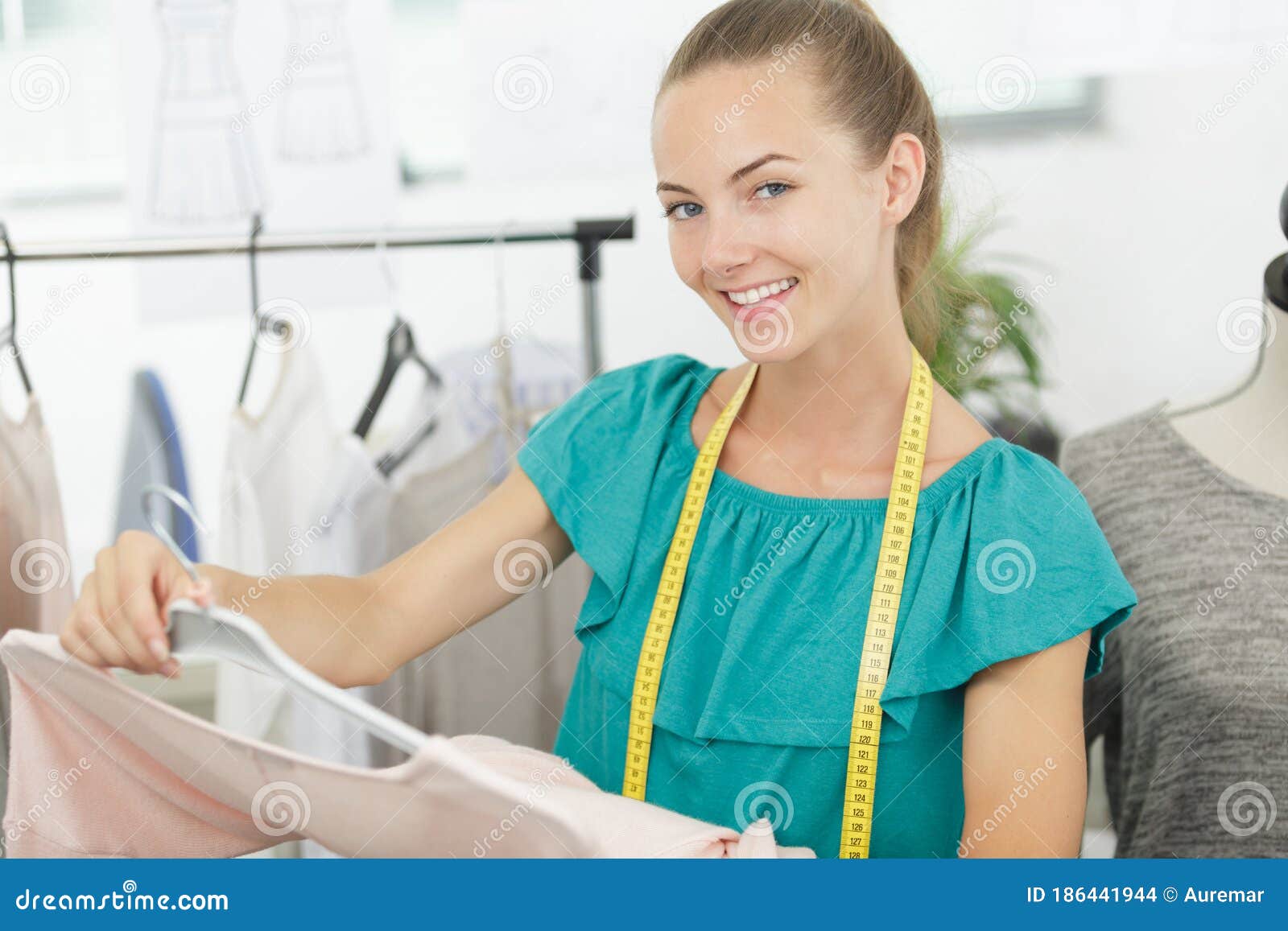 Female Shop Assistant Offering Clothes To Customer Stock Photo - Image ...