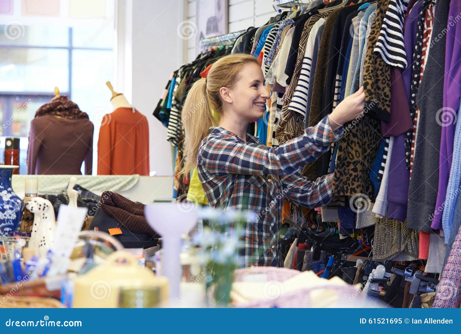 female shopper in thrift store looking at clothes