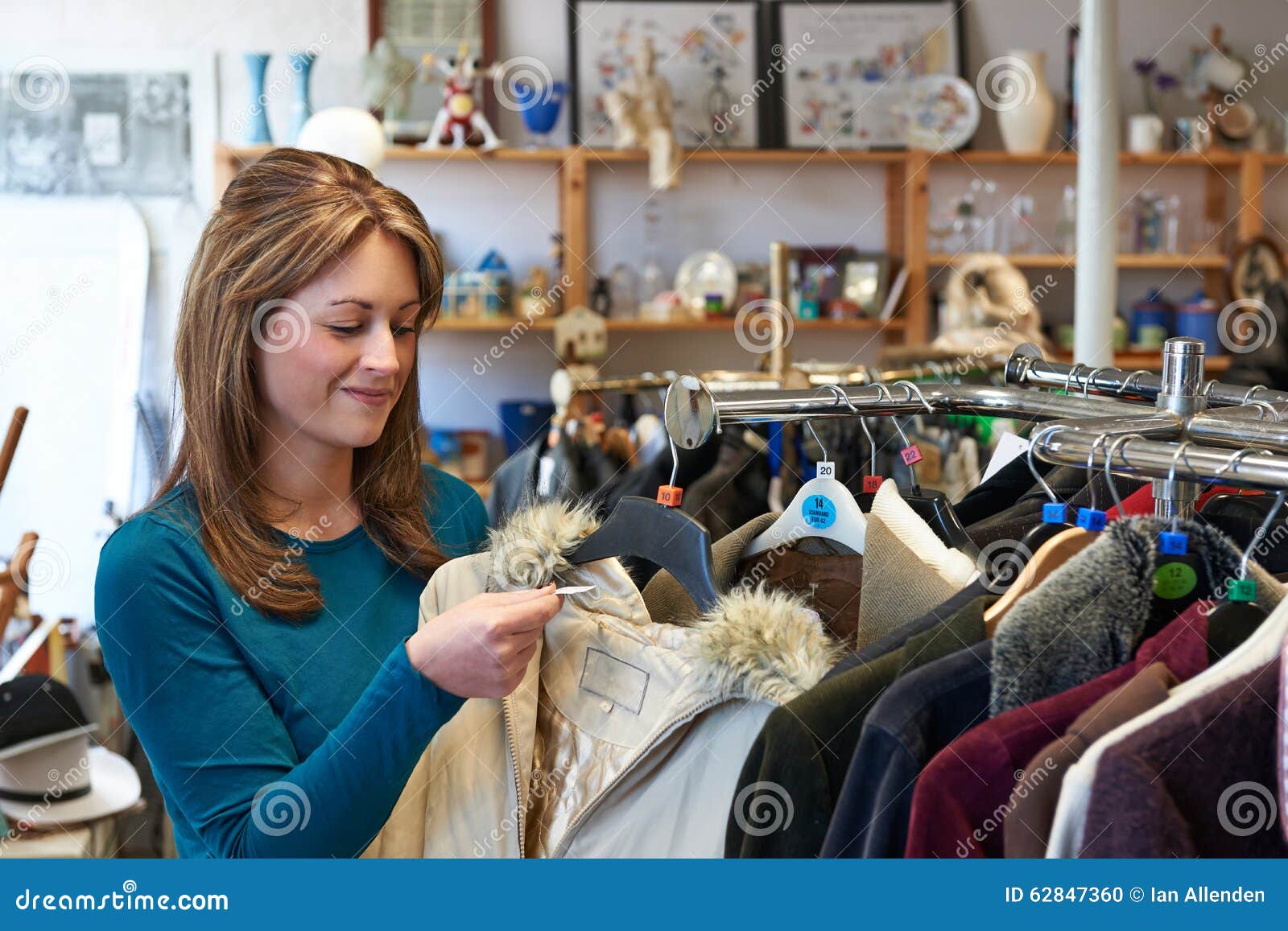 female shopper in thrift store looking at clothes