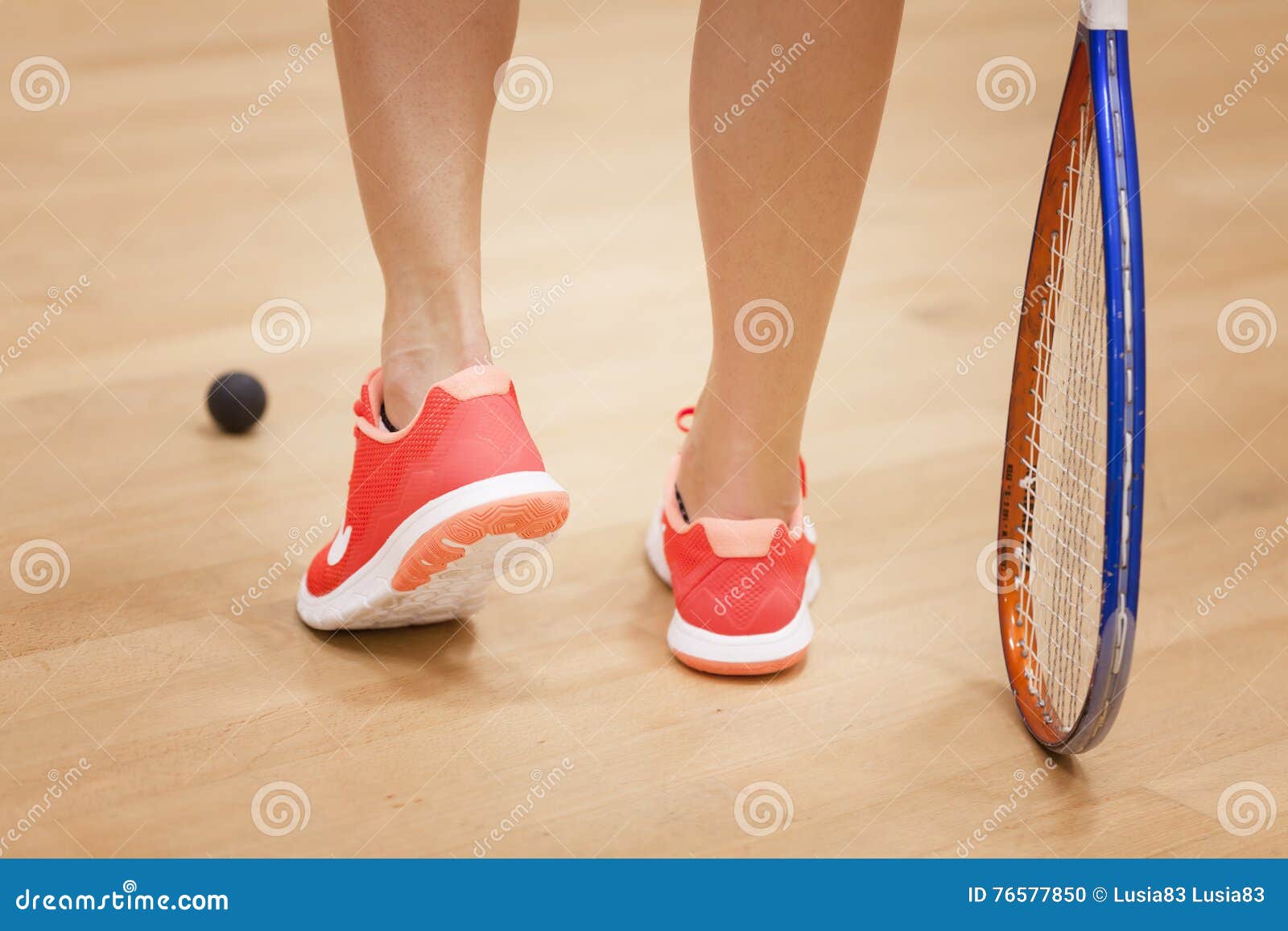 Female Squash Player Hiting a Ball in a Squash Court Stock Photo