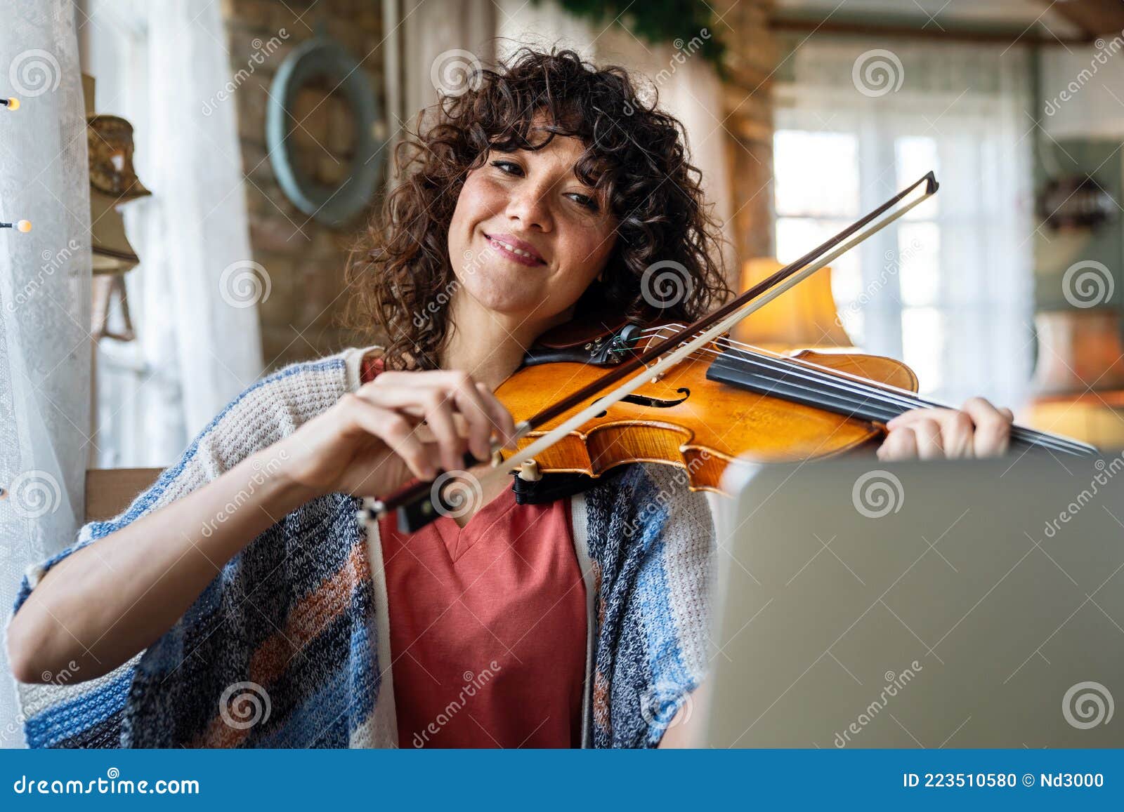 Woman Student Learns To Play the Violin Online Using a Laptop. Stock Image of happy: 223510580