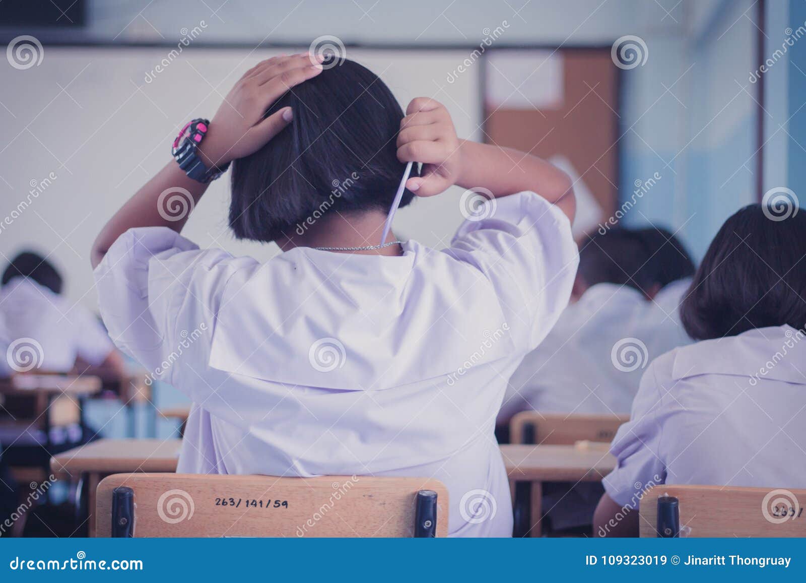 Female Students is Combing Her Hair in Classroom. Editorial Stock Image