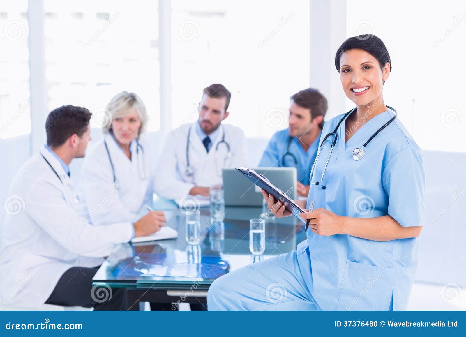 female surgeon holding reports with colleagues in meeting