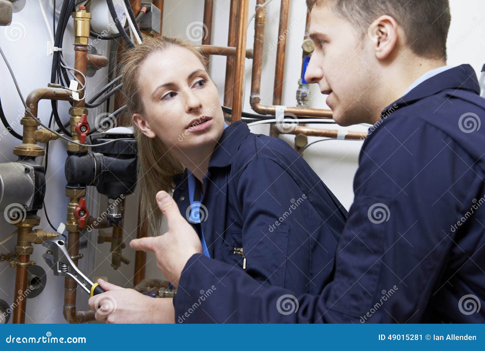 female trainee plumber working on central heating boiler