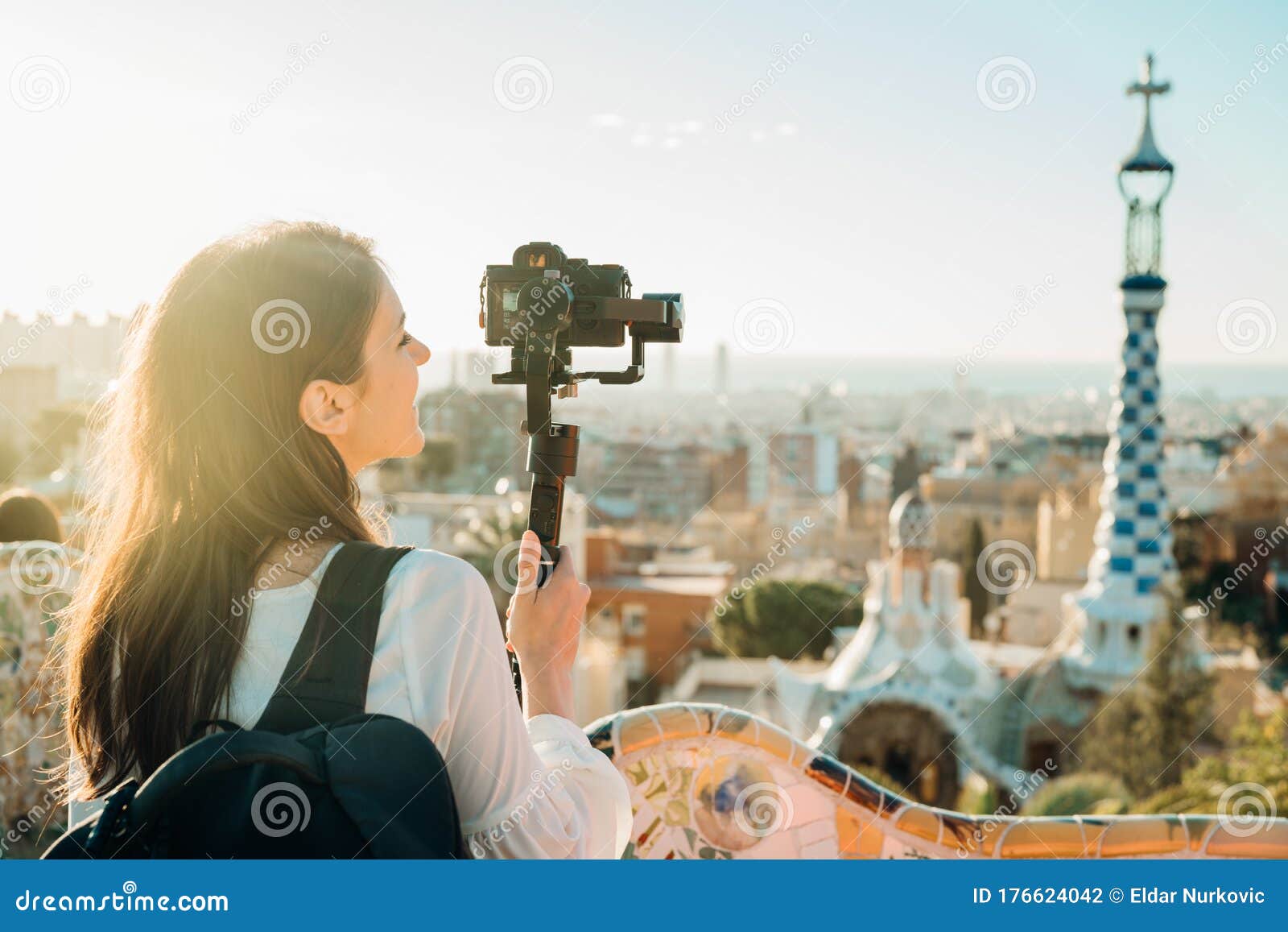 female travel photographer/videographer and bloger using camera with gimbal stabiliser crane in barcelona,spain.travel photography