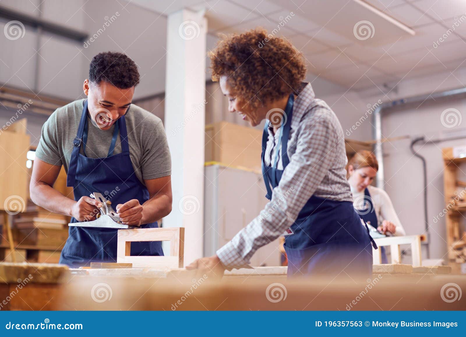 Female Tutor with Carpentry Student in Studying for