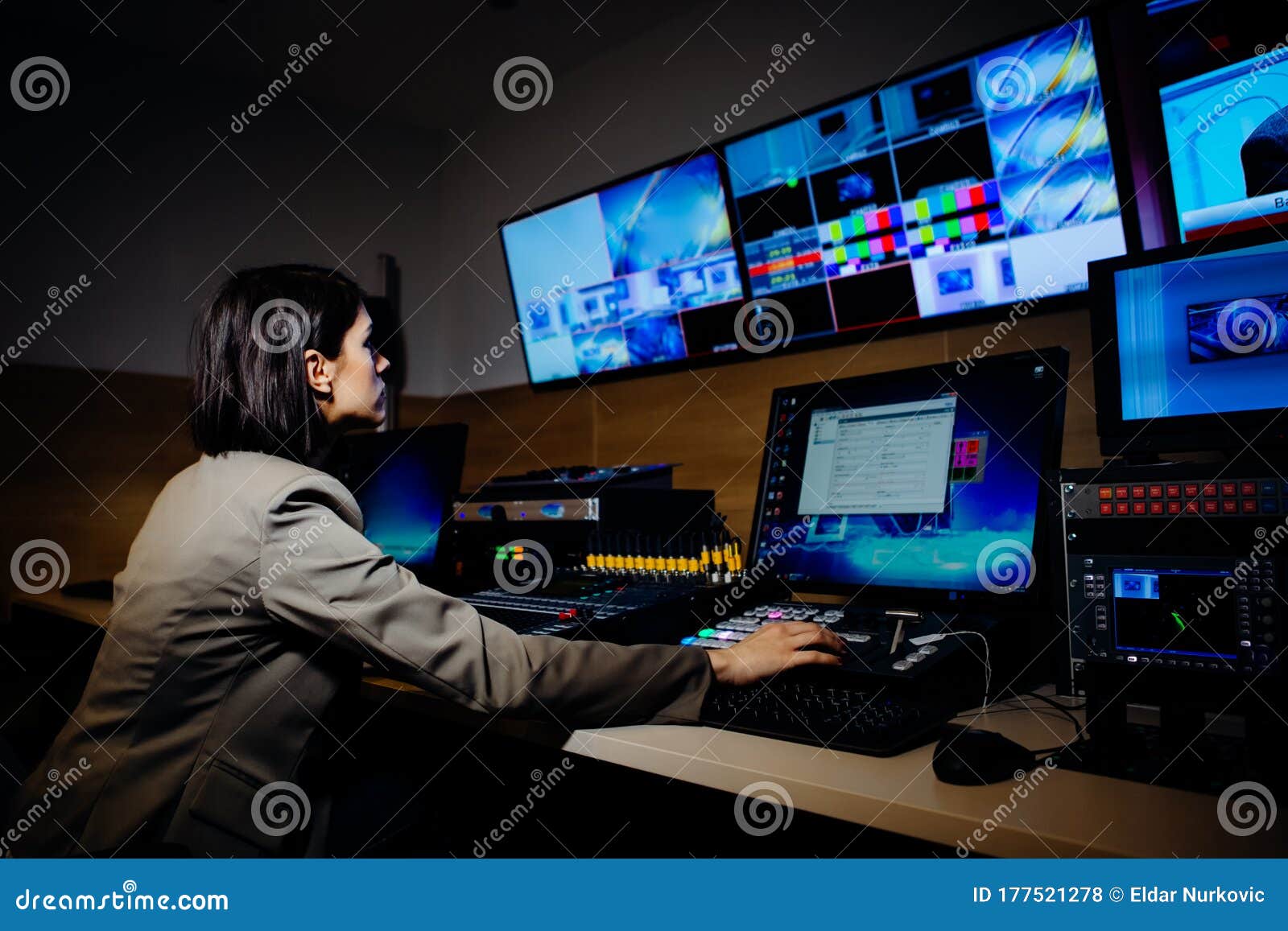 female tv director control editing room in television studio.operating vision mixer console equipment in a broadcast panel gallery