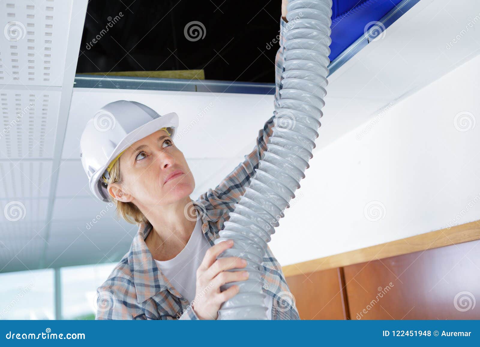 Female Worker Fitting Ventilation System in Buildings Ceiling Stock