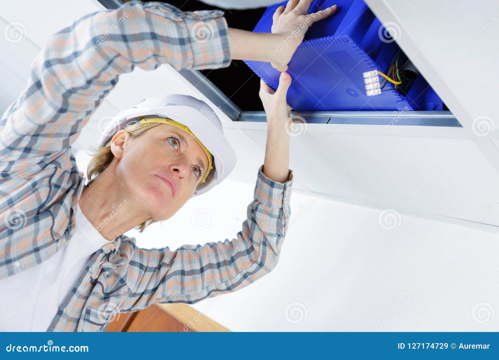 Female Worker Fitting Ventilation System in Buildings Ceiling Stock