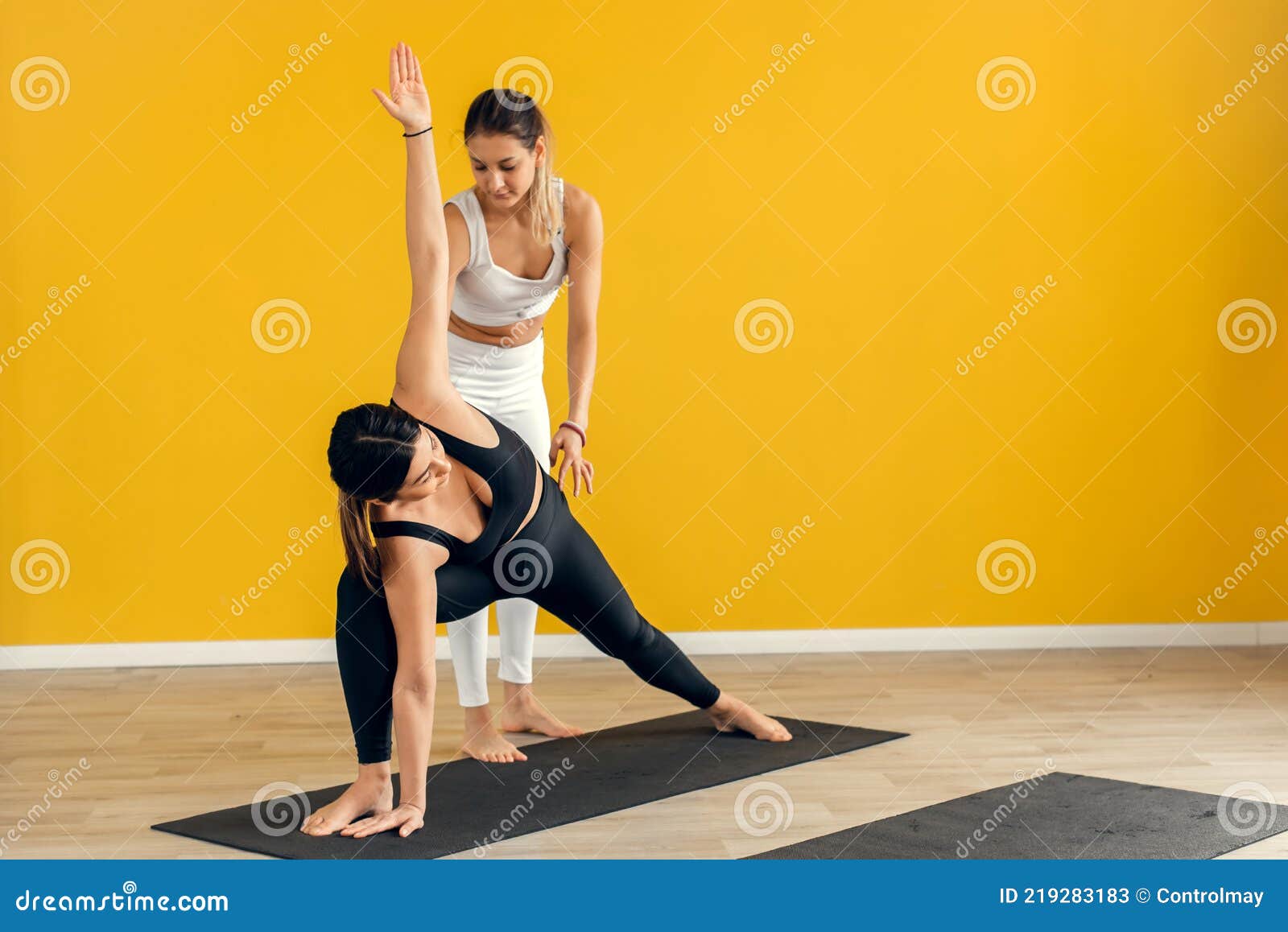 A Female Yoga Coach Controls the Performance of a Pose, Asana