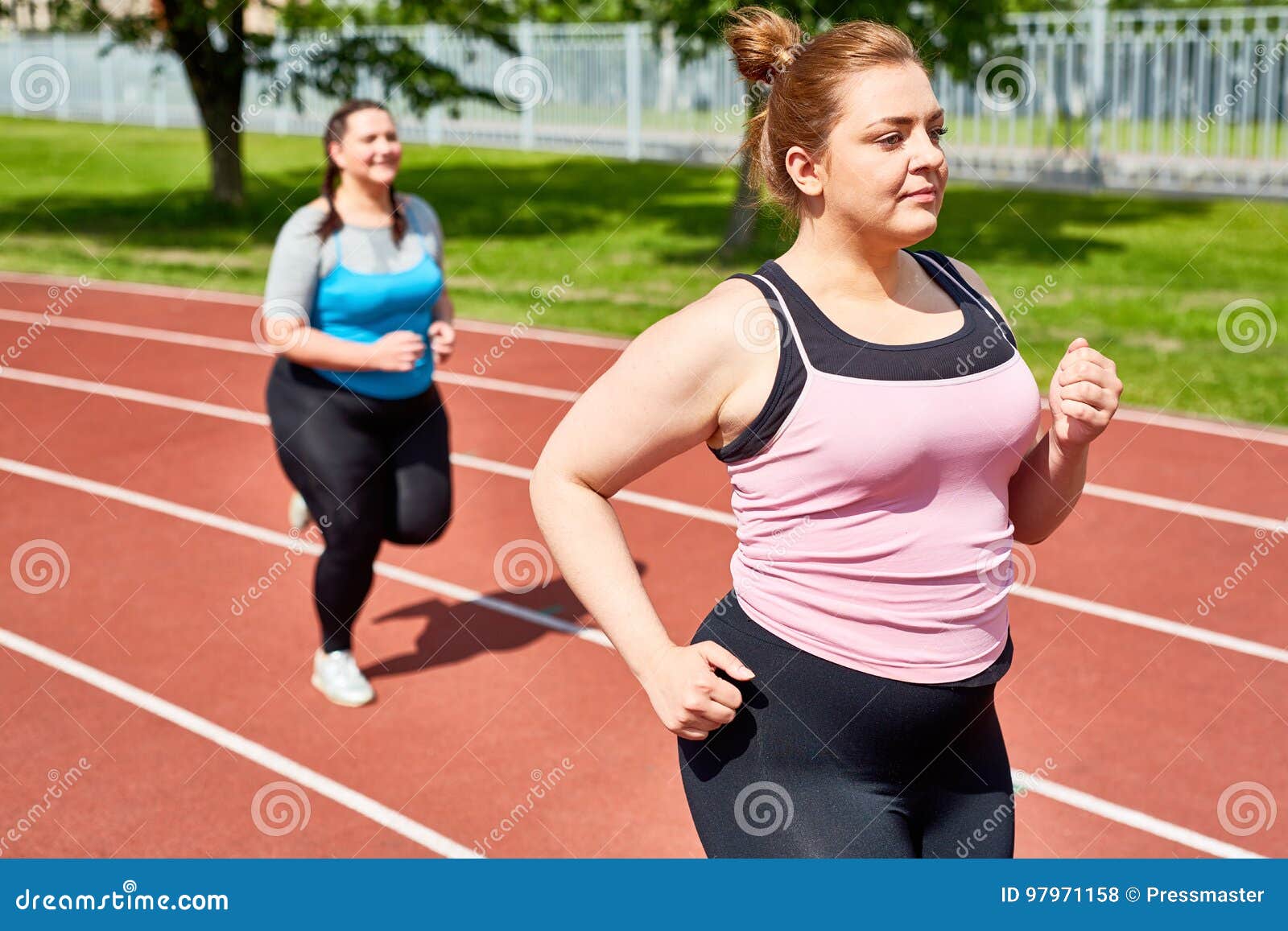 https://thumbs.dreamstime.com/z/females-running-active-determined-over-sized-women-jogging-stadium-morning-97971158.jpg