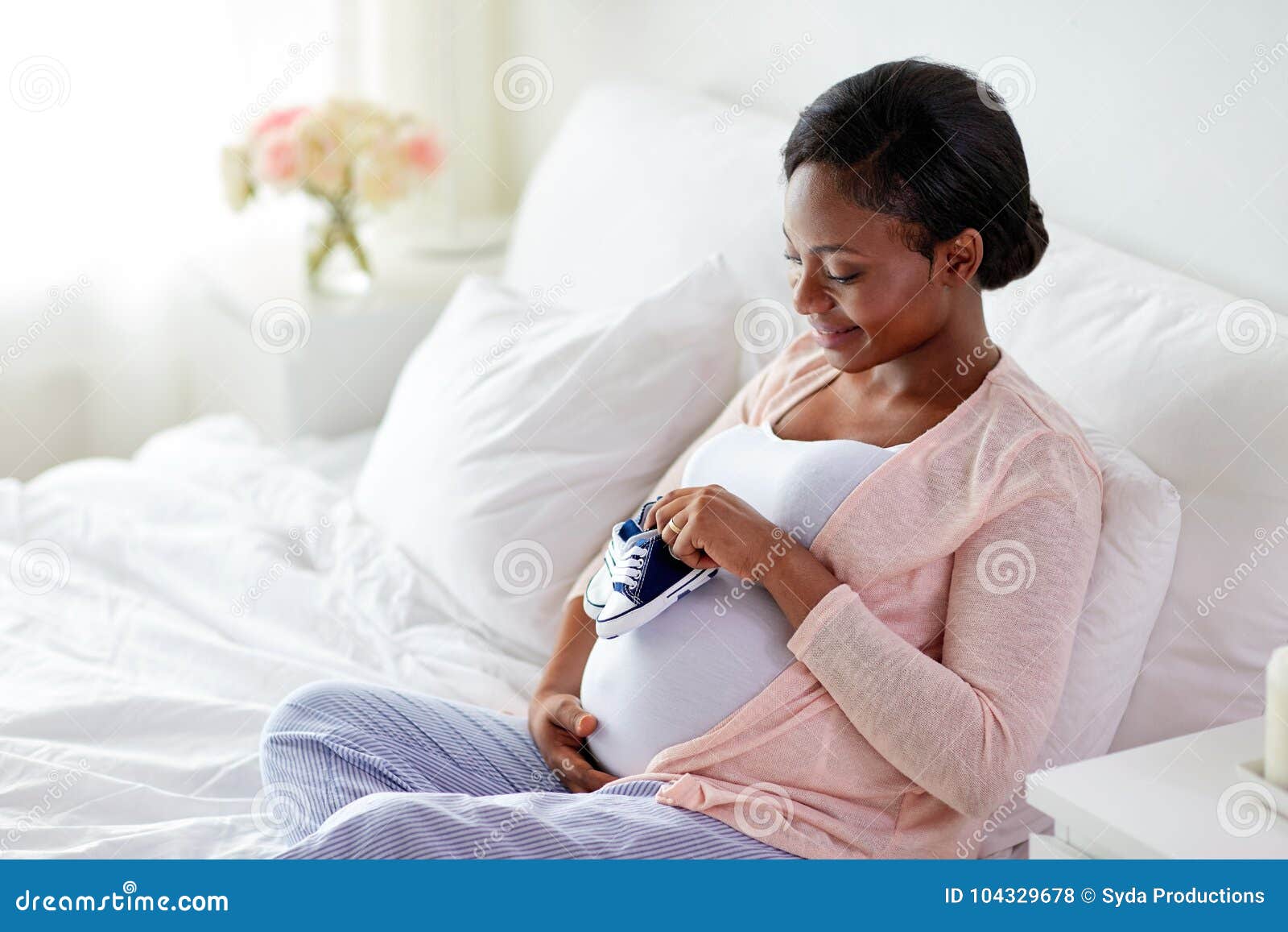 Femme Africaine Enceinte Avec Des Petits Chaussons De Bebe Dans Le Lit Photo Stock Image Du Esperance Indoors