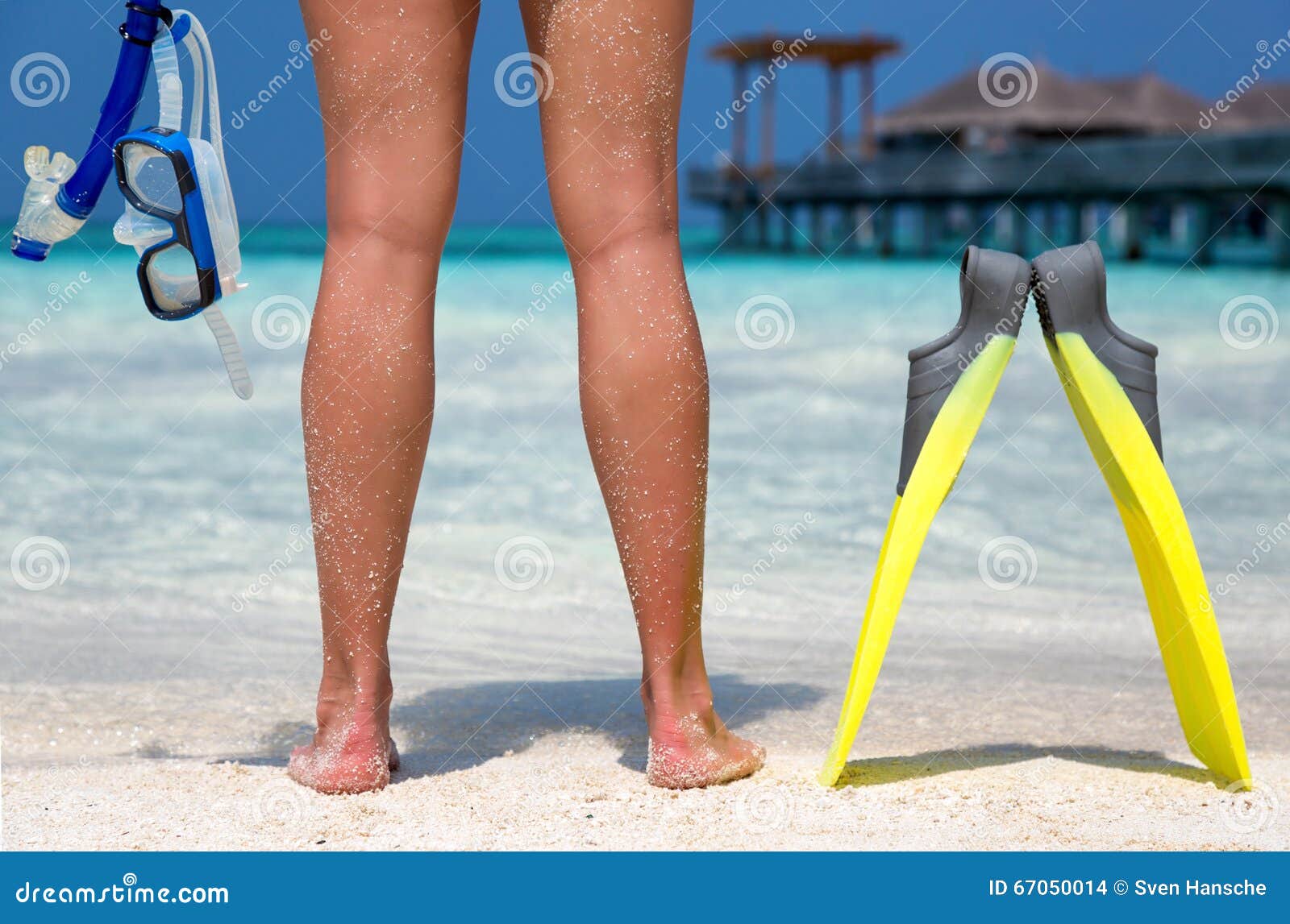 Femme avec l'équipement naviguant au schnorchel se tenant sur une plage en Maldives