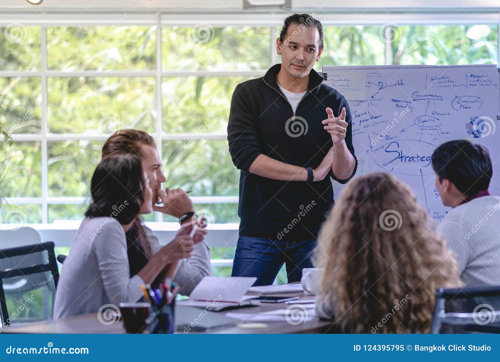 Femme d'affaires soulevant la main pour poser la question équiper devant moi. Femme d'affaires soulevant la main pour poser la question aux hommes devant le lieu de réunion tandis qu'il explique le graphique et le graphique de gestion