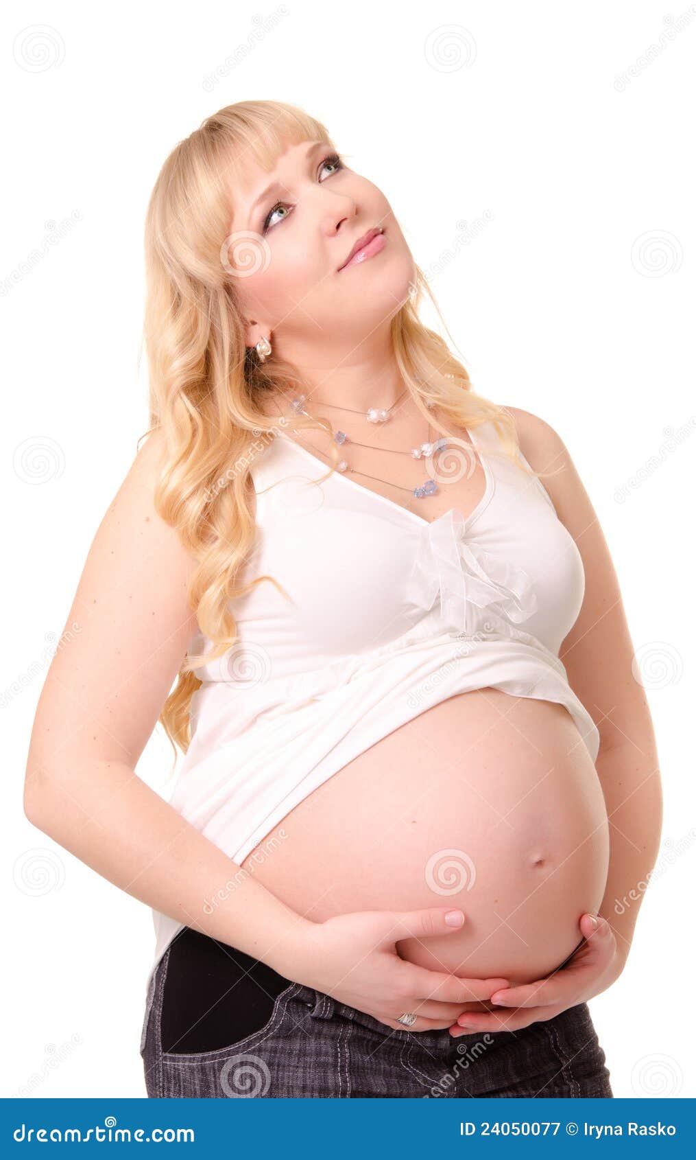 Femme enceinte caressant son ventre et rêver. Femme enceinte caressant son ventre et recherchant d'isolement sur le blanc