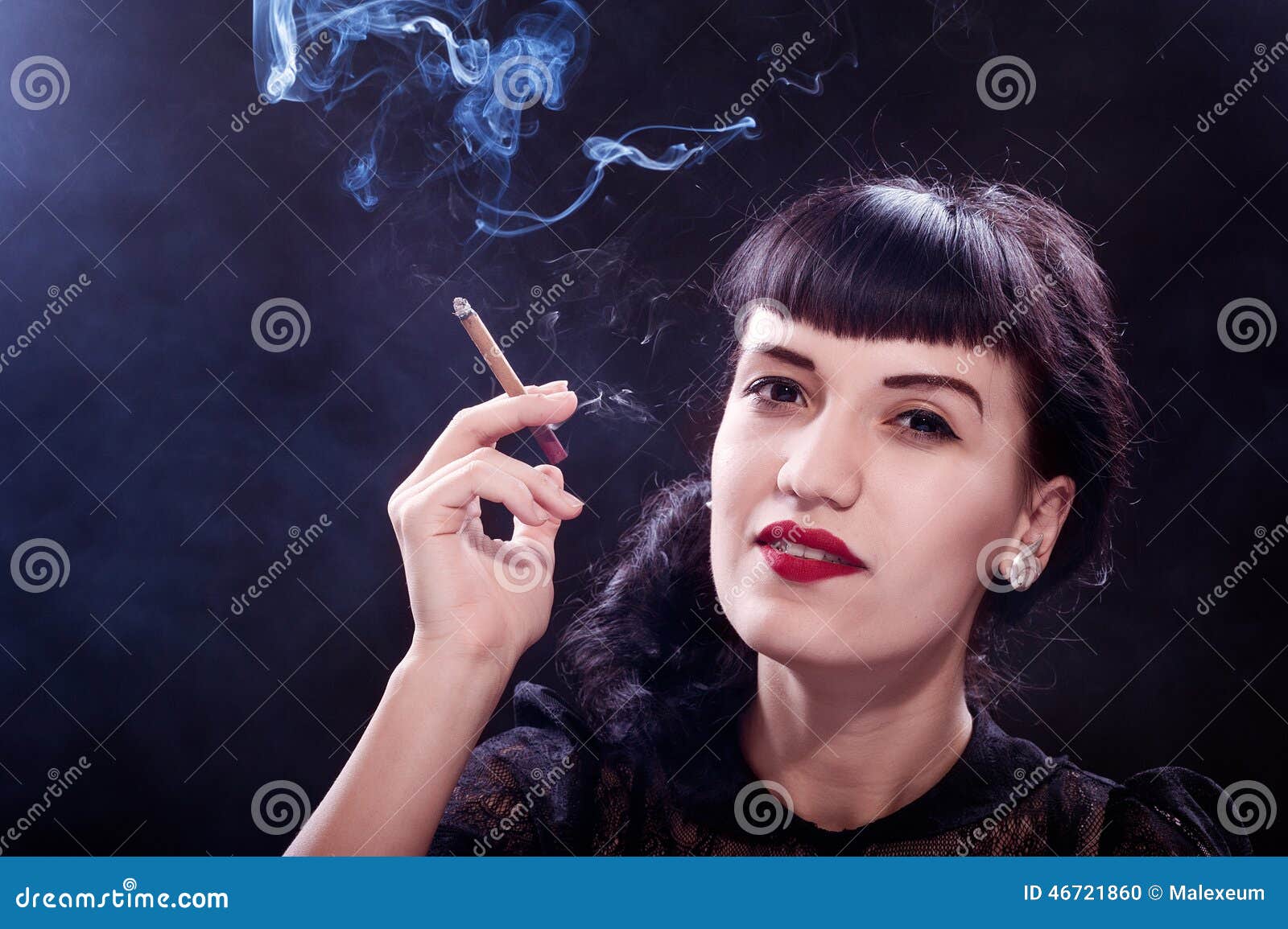 Femme fatal. Jovem mulher no charuto e no fumo guardando pretos