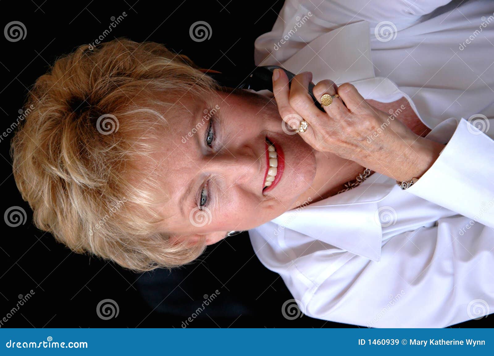 Femme mûr sur le téléphone portable. Une femme de sourire plus âgée d'affaires sur un téléphone portable regardant loin