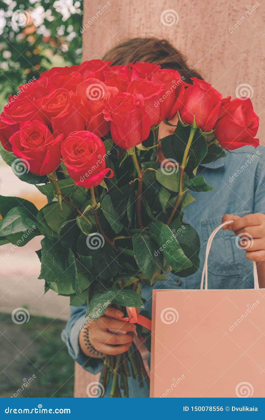 Femme Tenant Le Bouquet De Roses Rouges Et Le Paquet Actuel Rose Photo  stock - Image du vacances, commercial: 150078556