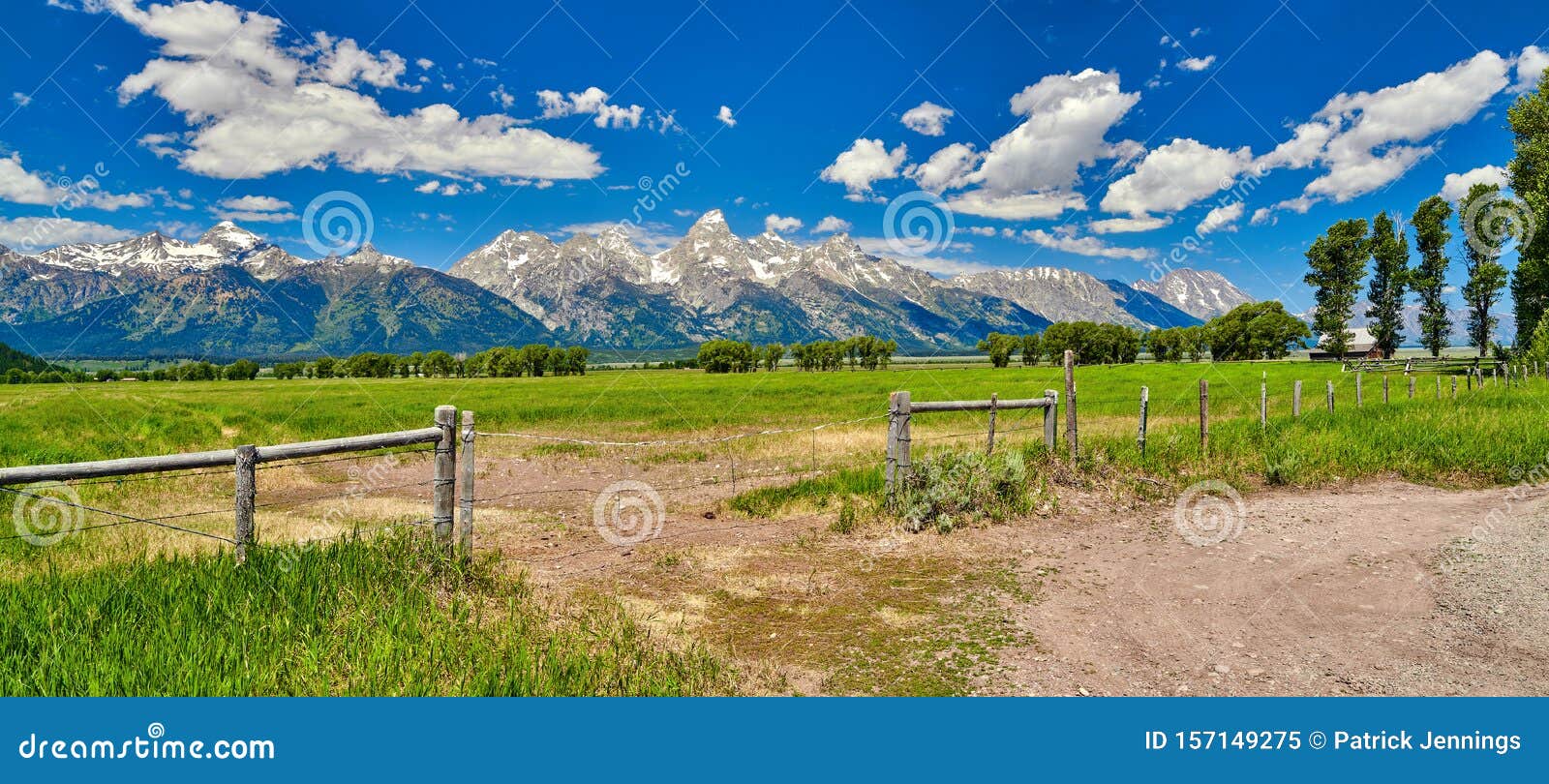 fence and field with the grand teton mountians in the background