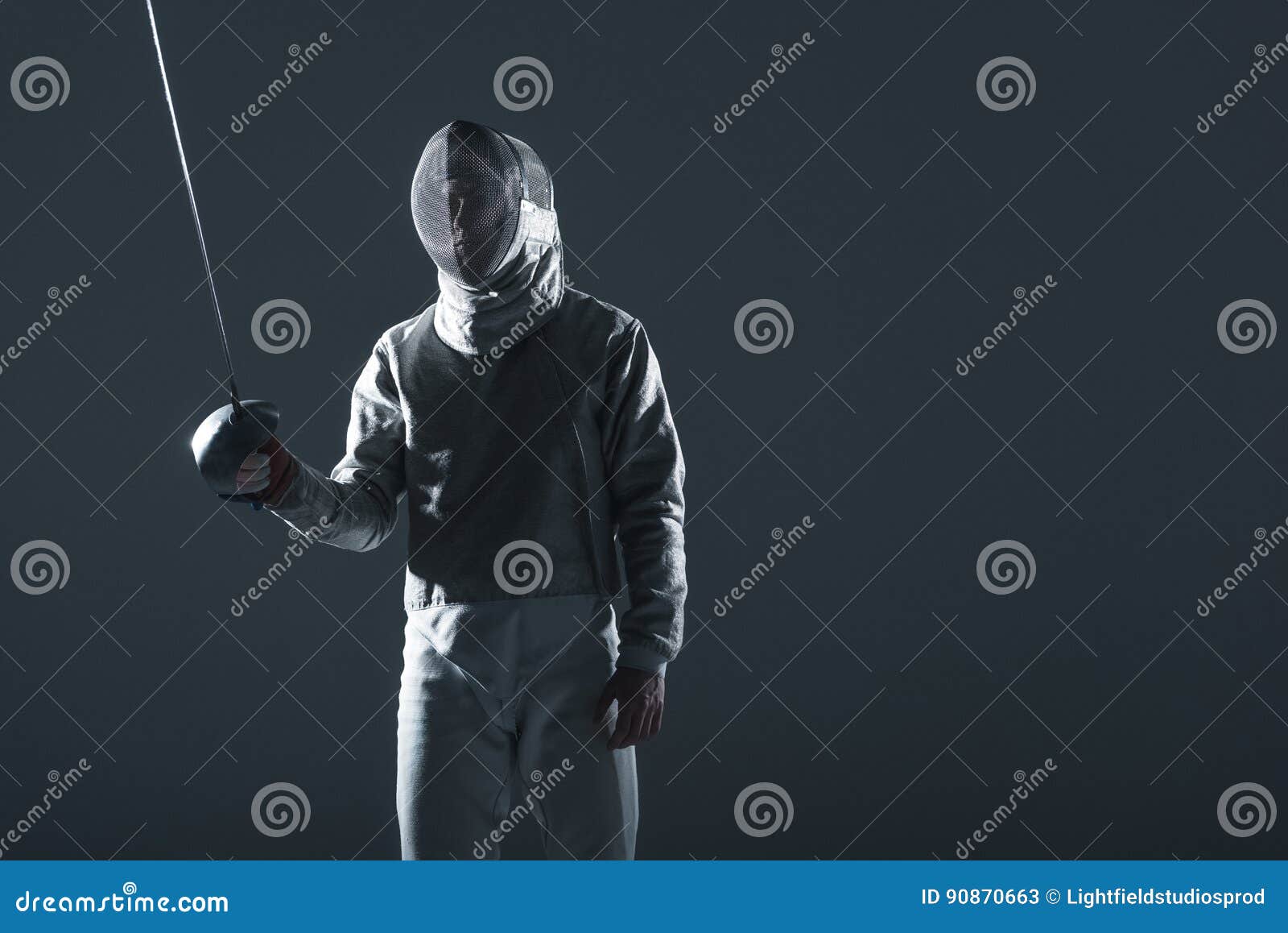 Fencer in Fencing Mask with Rapier Standing in Position on Grey Stock