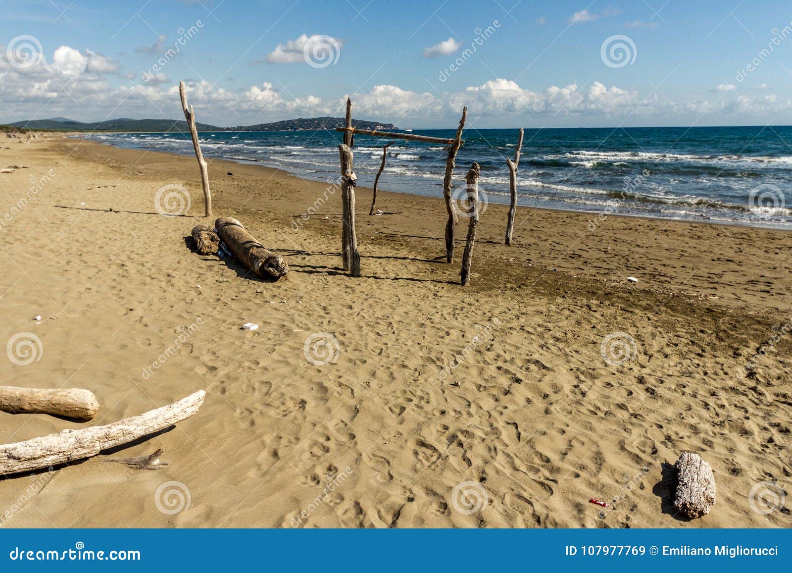 feniglia beach in tuscany wooden poles stuck on the beach