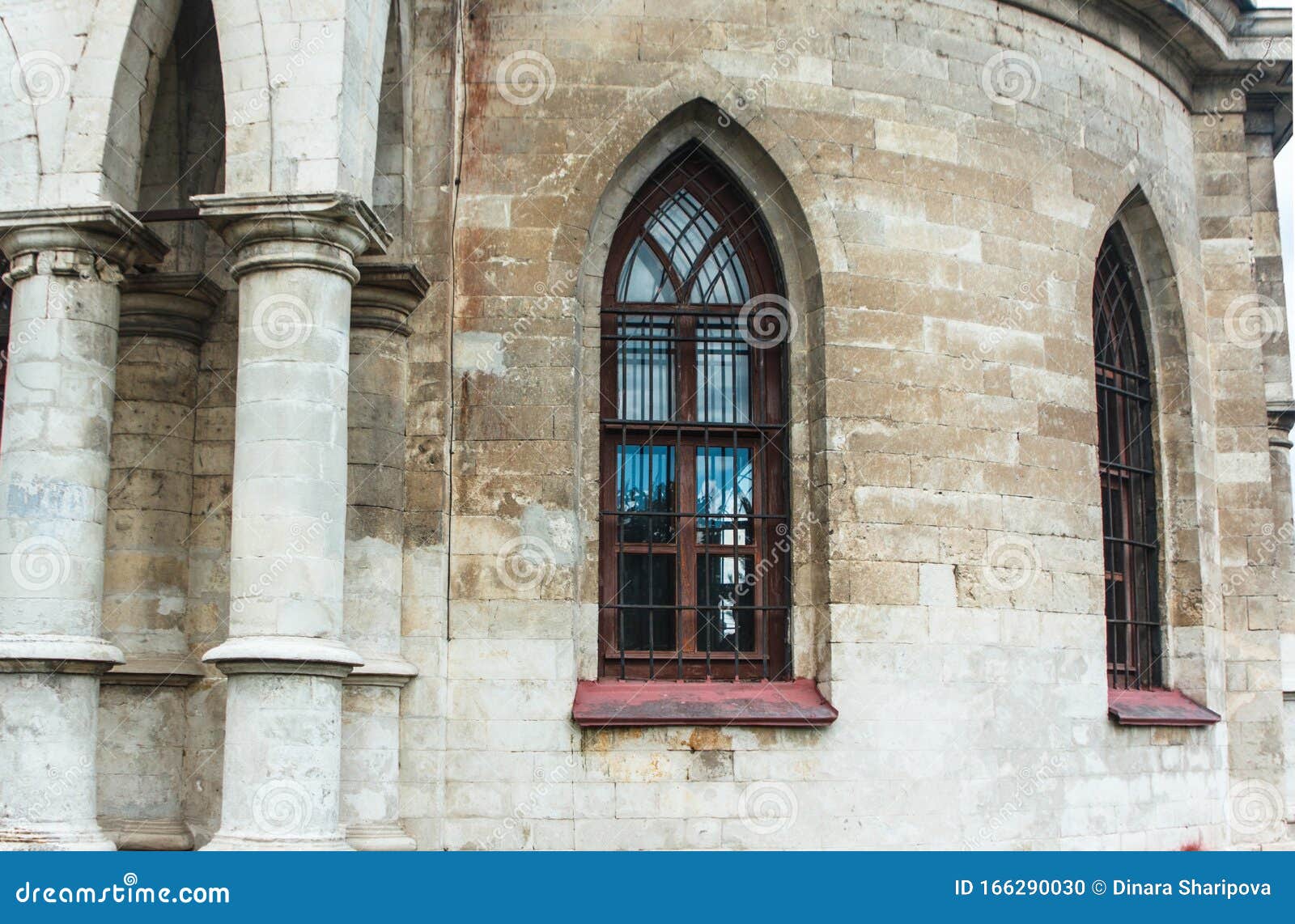 Fenster mit Bars in der gotischen Kirche aus weißem Stein, ein schönes historisches Gebäude in Europa