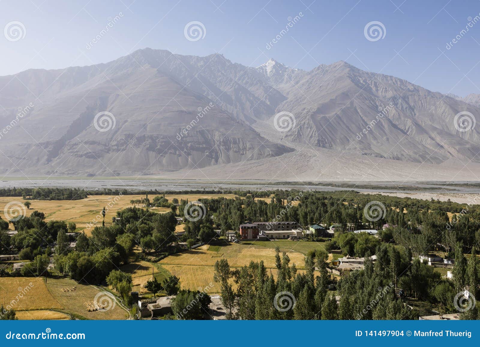 fertile wakhan valley near vrang in tajikistan. the mountains in the background are the hindu kush in afghanistan