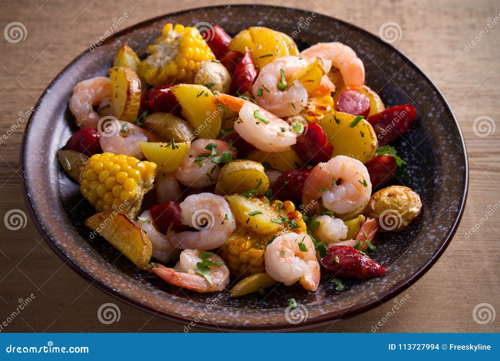 Fervura do camarão Camarões, salsichas fumado, batatas e milho na bacia na tabela de madeira horizontal