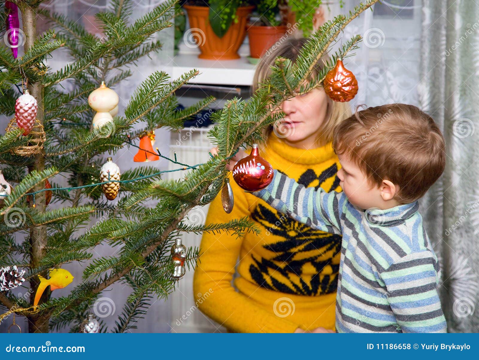 La famiglia decora l'albero di Natale per la festa del nuovo anno.
