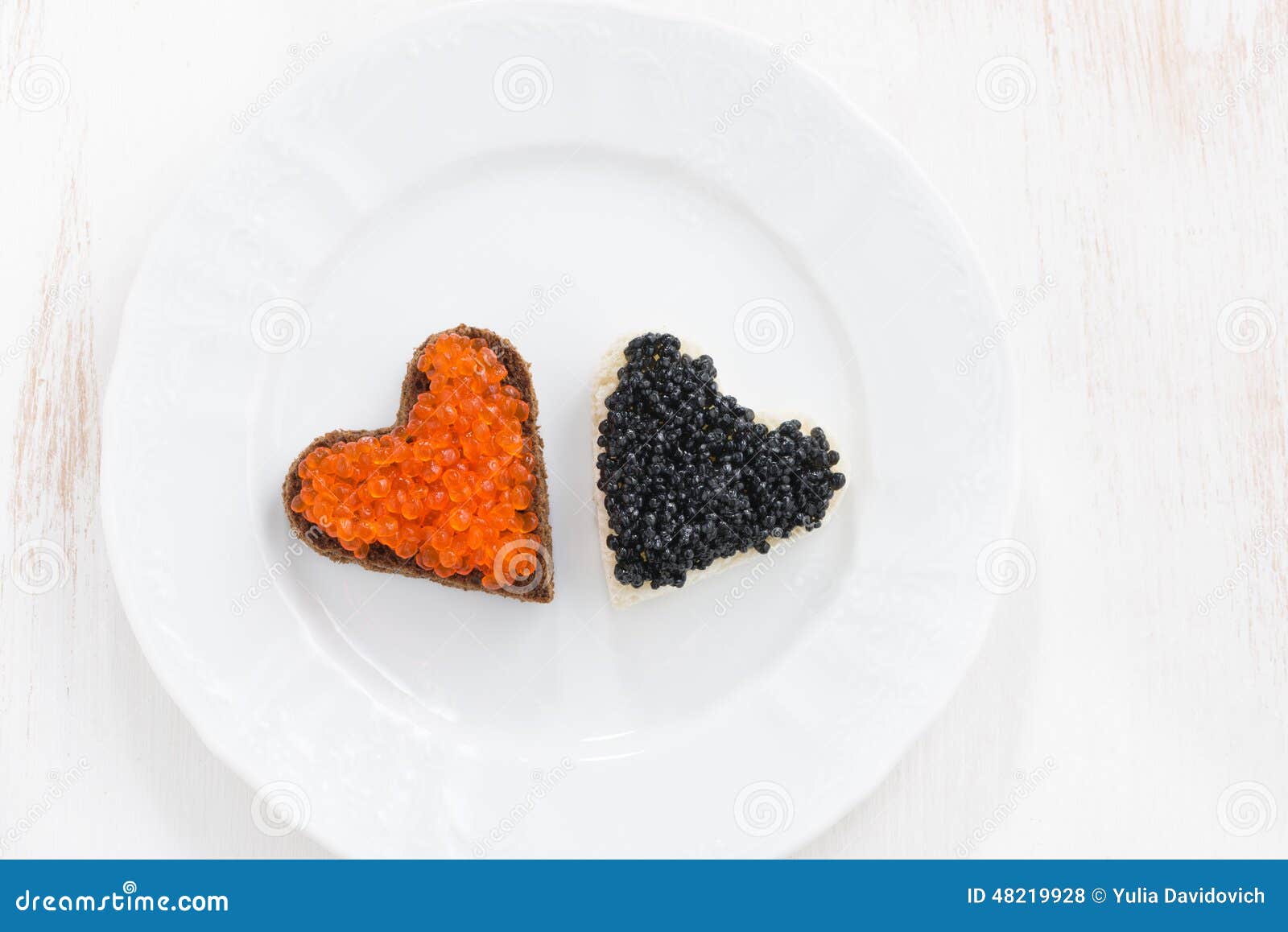 Festive Appetizer Toasts in Heart Shape on White Plate Stock Photo