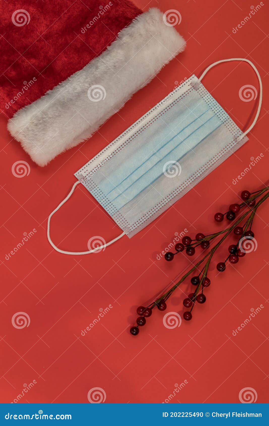 festive holiday santa hat with face mask and ornaments red background flat lay copy space