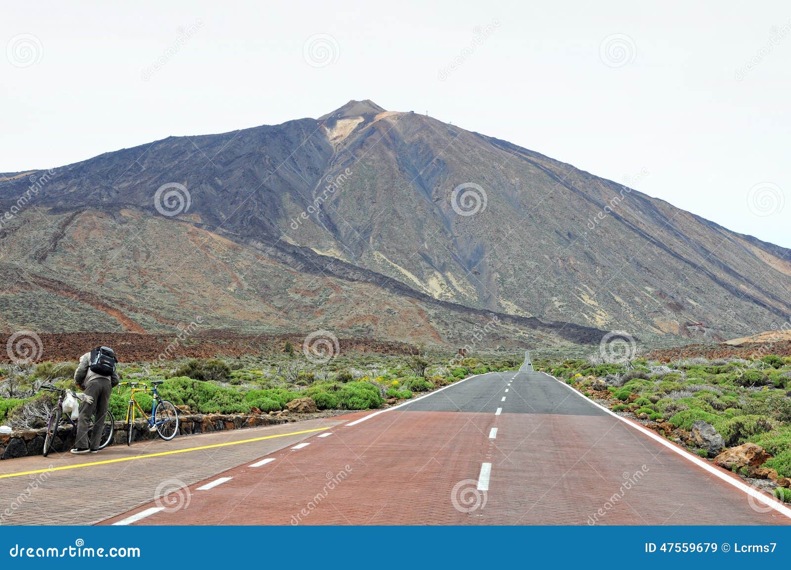 Fietser die op weg rusten die naar pico del teide leiden. DEL TEIDE NATIONAL PARK, TENERIFE SPANJE 8 Mei 2011: een fietser die op de weg rusten die door het de natiepark leiden van delteide (Tenerife, Spanje) op achtergrond de vulkaan pico del teide