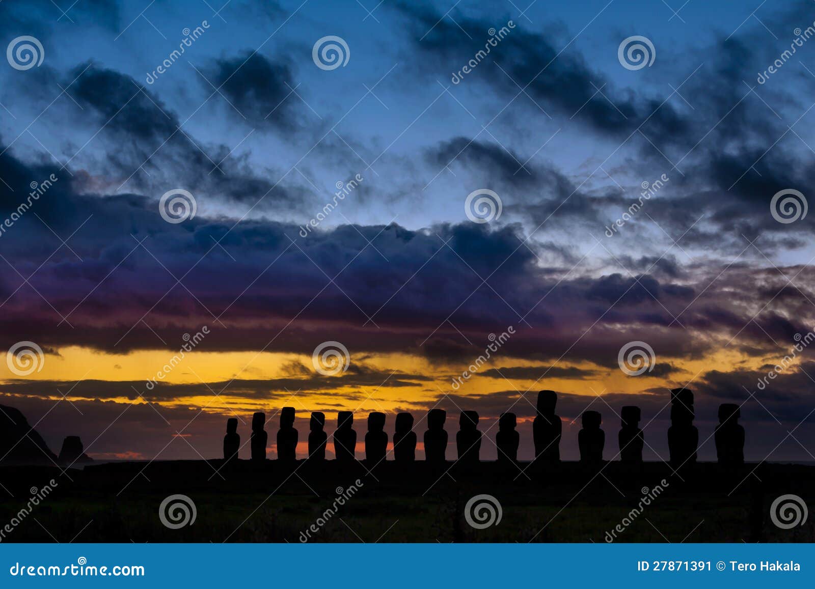 fifteen moai against orange and blue sunrise