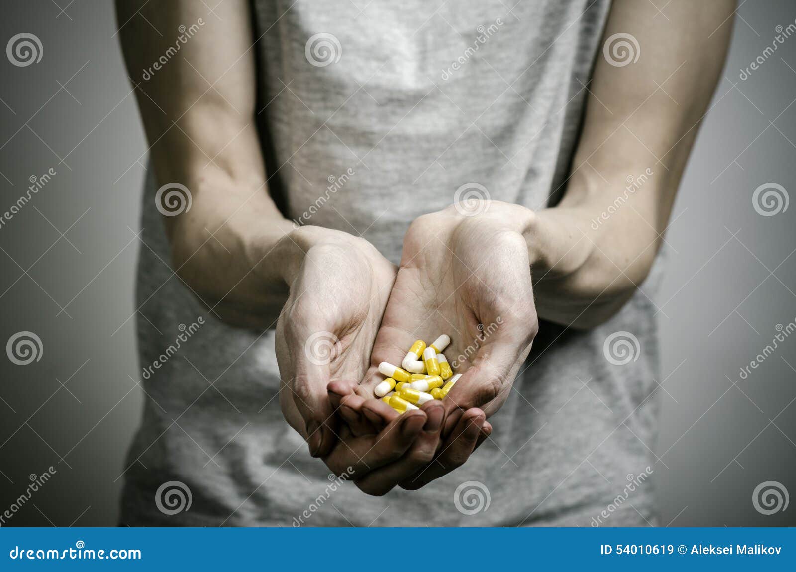 the fight against drugs and drug addiction topic: addict holding a narcotic pills on a dark background