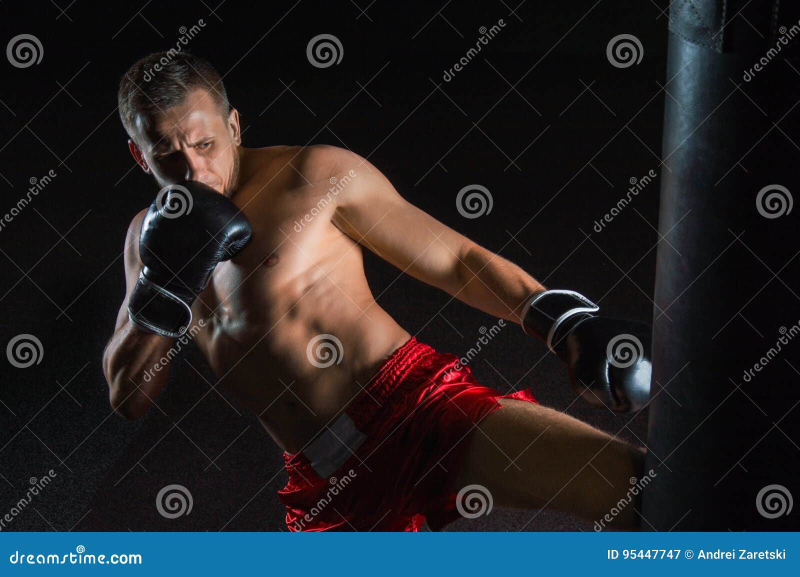 The Fighter of Mixed Martial Arts Beats the Bag with His Left Foot