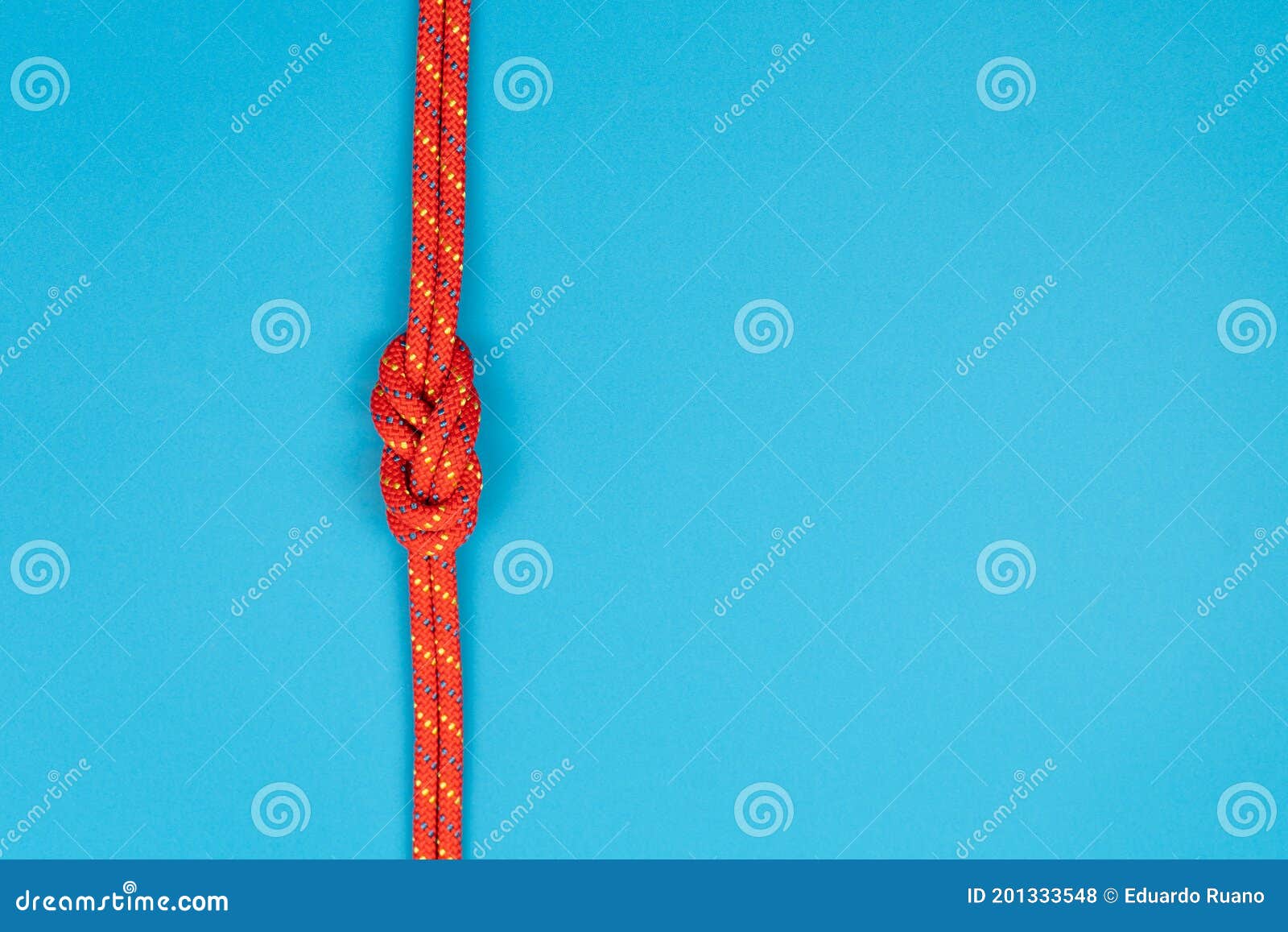 Figureeight Knot with Red Climbing Rope on Blue Background Stock Photo