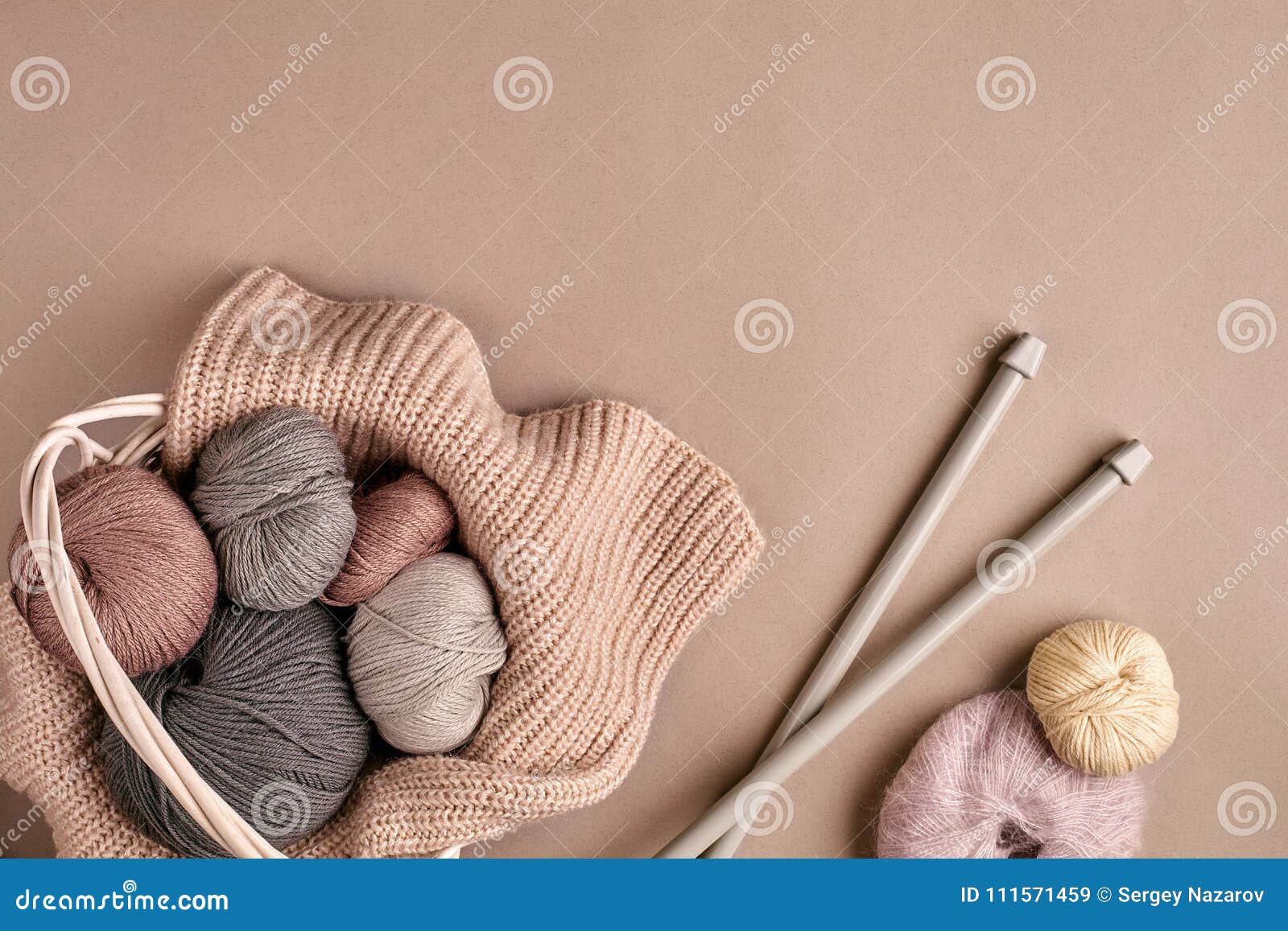 Fil coloré différent dans le panier avec des aiguilles de tricotage Vue supérieure. Fil coloré différent dans le panier avec des aiguilles de tricotage sur un fond beige Vue supérieure Copiez l'espace Durée toujours 1 Configuration plate