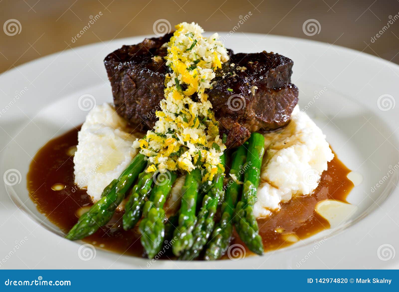 Filet on a Bed of Asparagus and Mashed Potatoes with Gravy Stock Photo