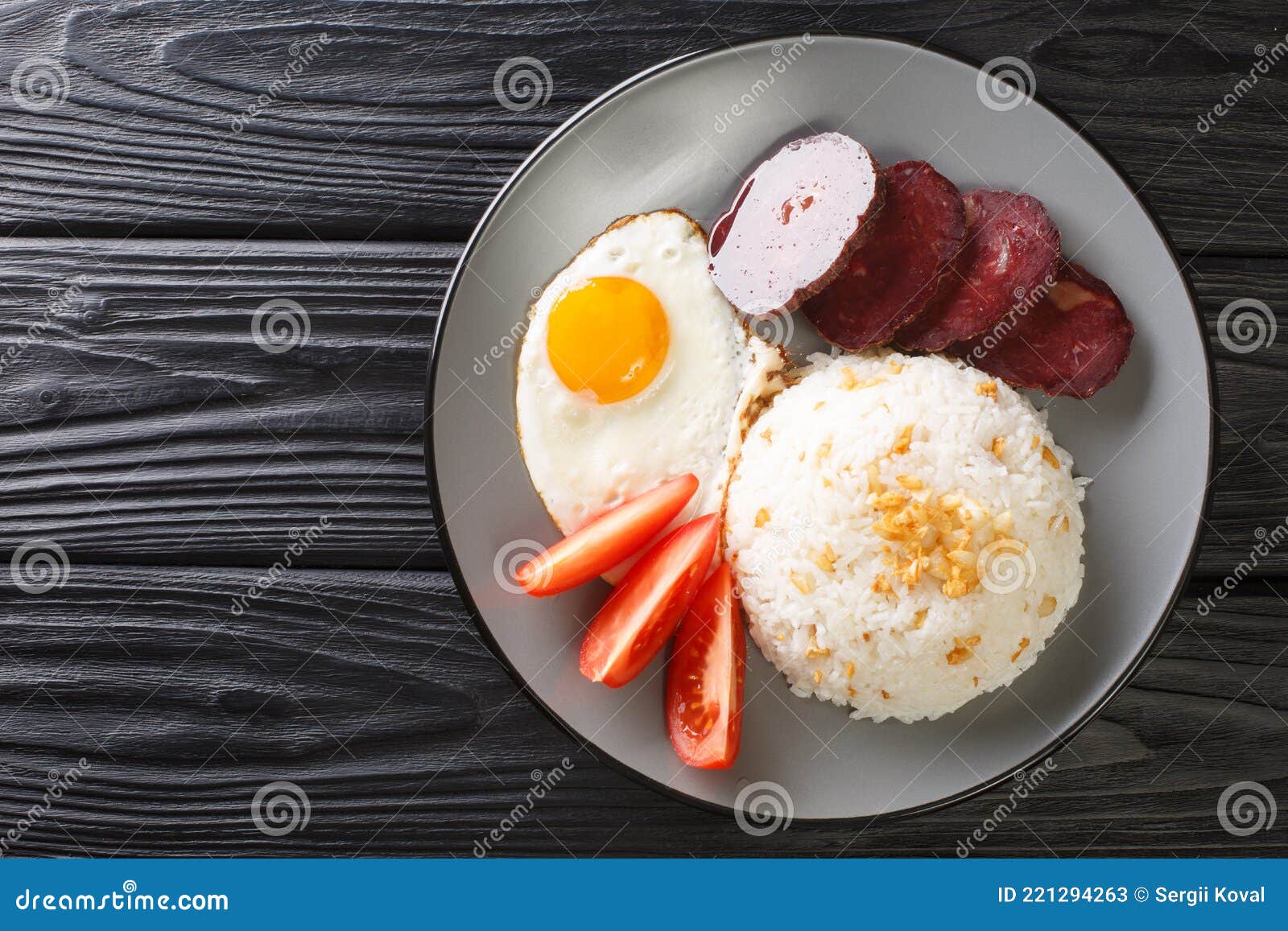 filipino breakfast sinangag garlic rice with fried egg and meat close-up in a plate. horizontal top view