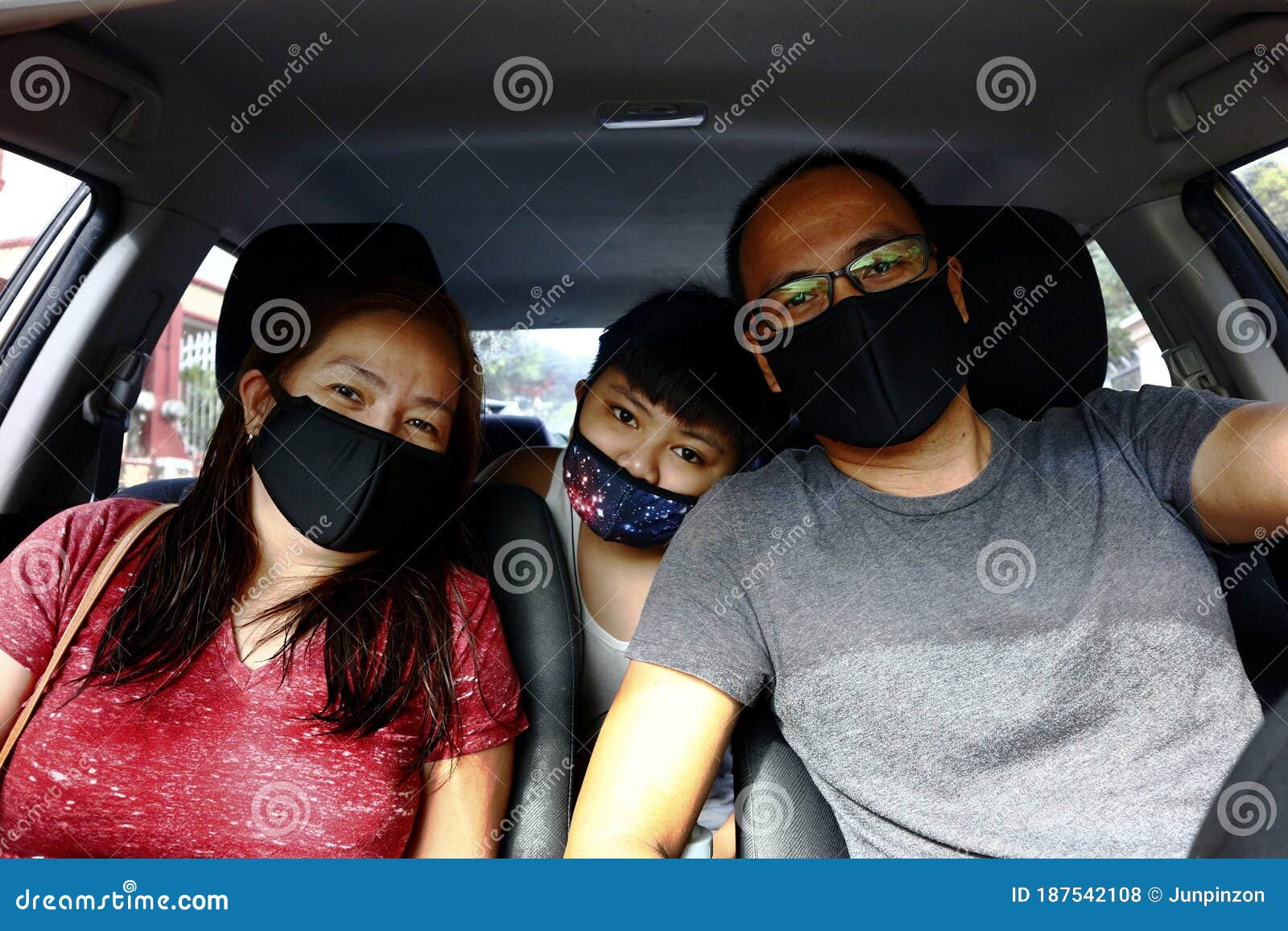 filipino family with face mask on while inside a car