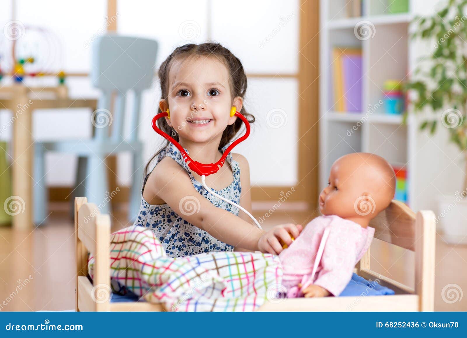 Fille D'enfant Jouant Le Jeu De Rôle De Docteur Examinant Sa Poupée  Utilisant Le Stéthoscope Se Reposant à La Salle De Jeux à La Photo stock -  Image du classroom, santé: 68252436