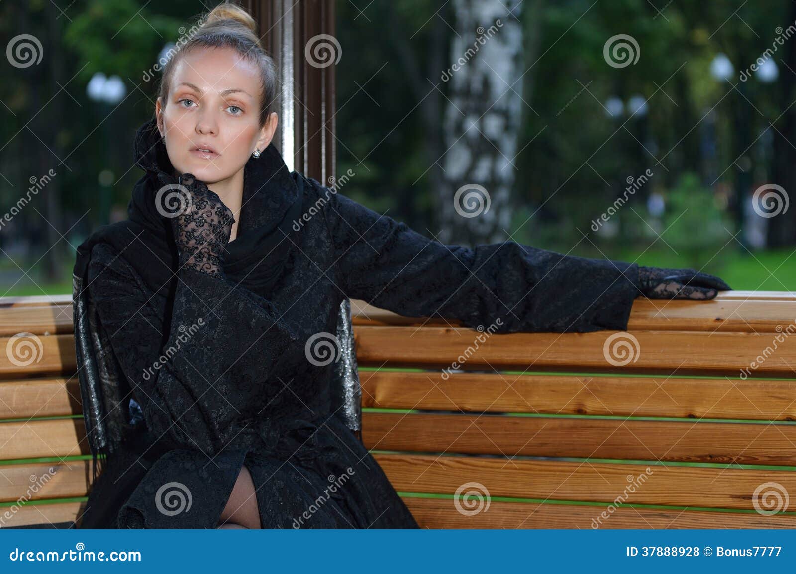 Fille dans le manteau noir en parc