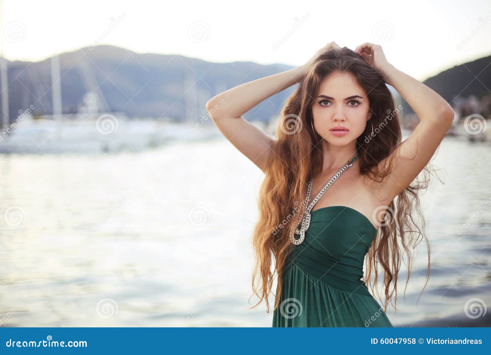 Fille de l'adolescence de pose attirante sur la plage au coucher du soleil en le yacht. Fille de l'adolescence de pose attirante sur la plage au coucher du soleil par le fond de yacht Portrait extérieur de femme de modèle de brune de mode avec de longs cheveux