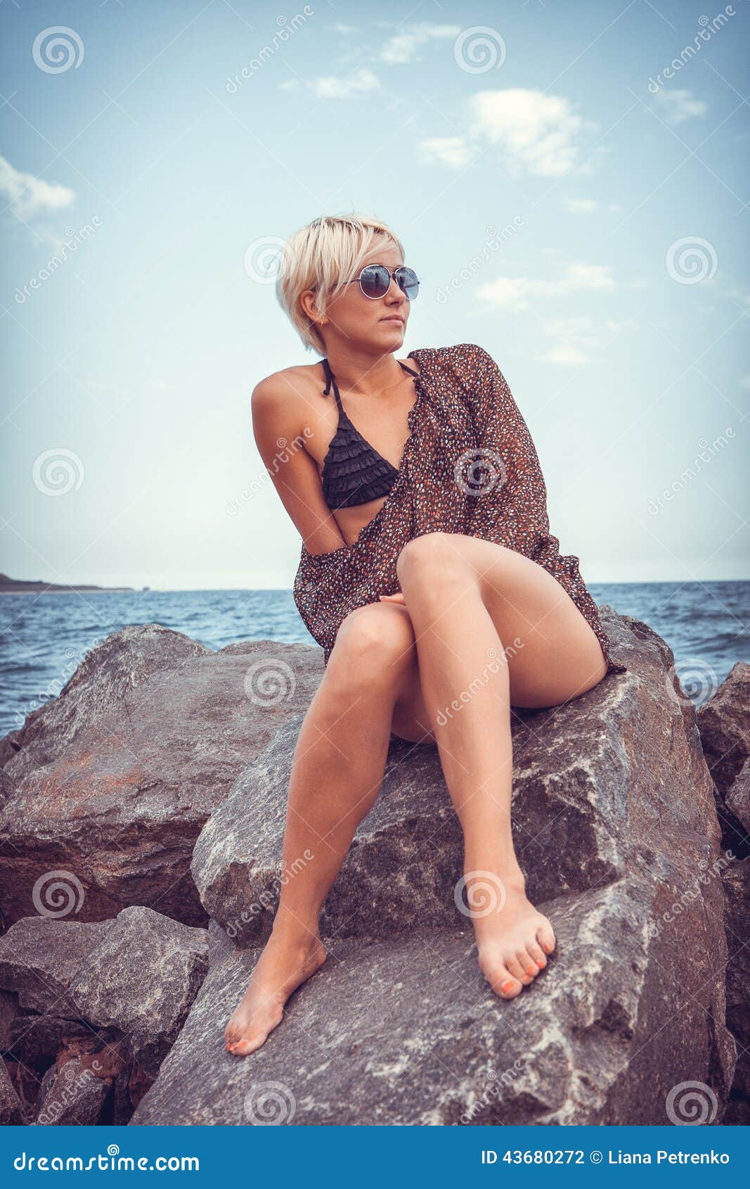 Belle fille sur la côte en pierre près de la mer