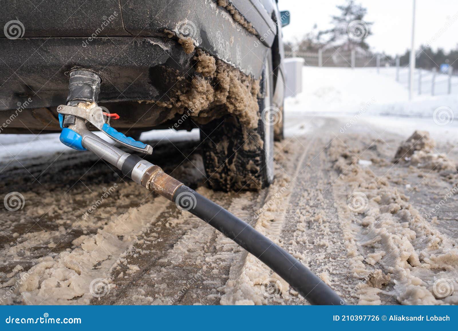 Filling the Car from the Bottom of the Bumper with Gas in the Winter at the Gas Station Stock