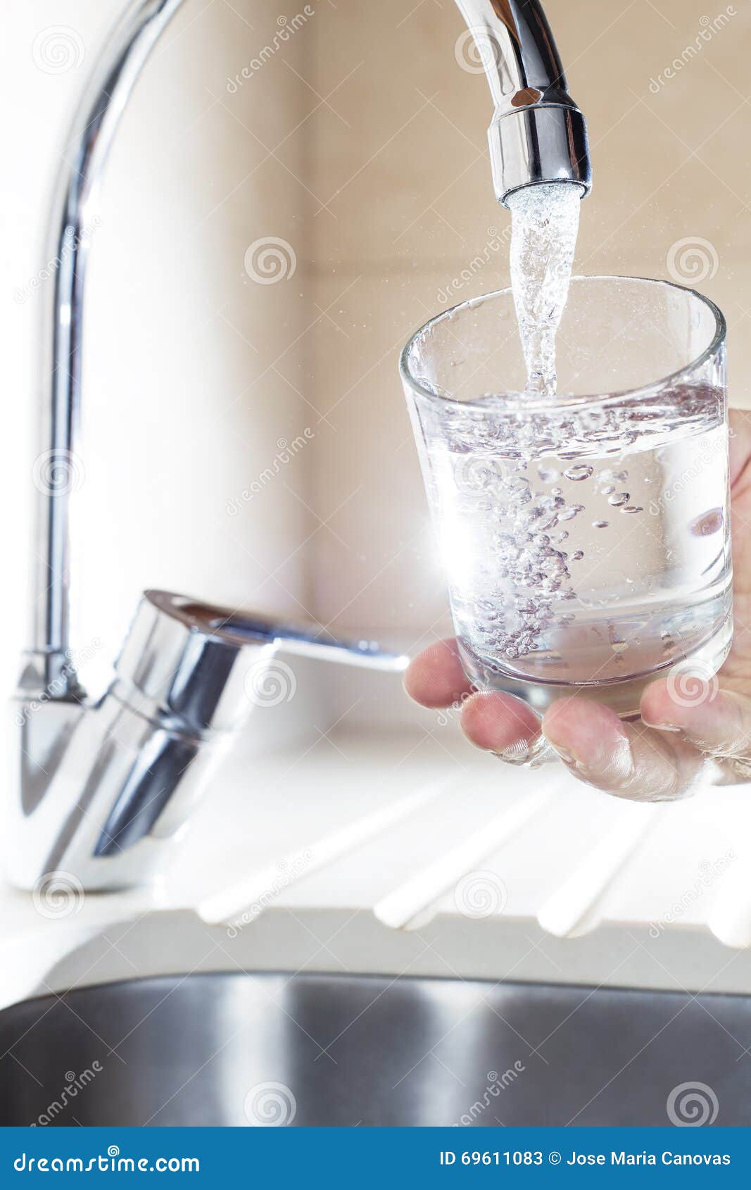 filling glass of water in hand from kitchen faucet